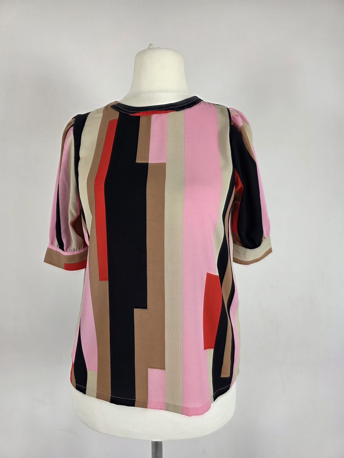 Oryginalna bluzka Vero Moda w różowo-brązowe geometryczne wzory, rozmiar XS, idealna do eleganckich i casualowych stylizacji.