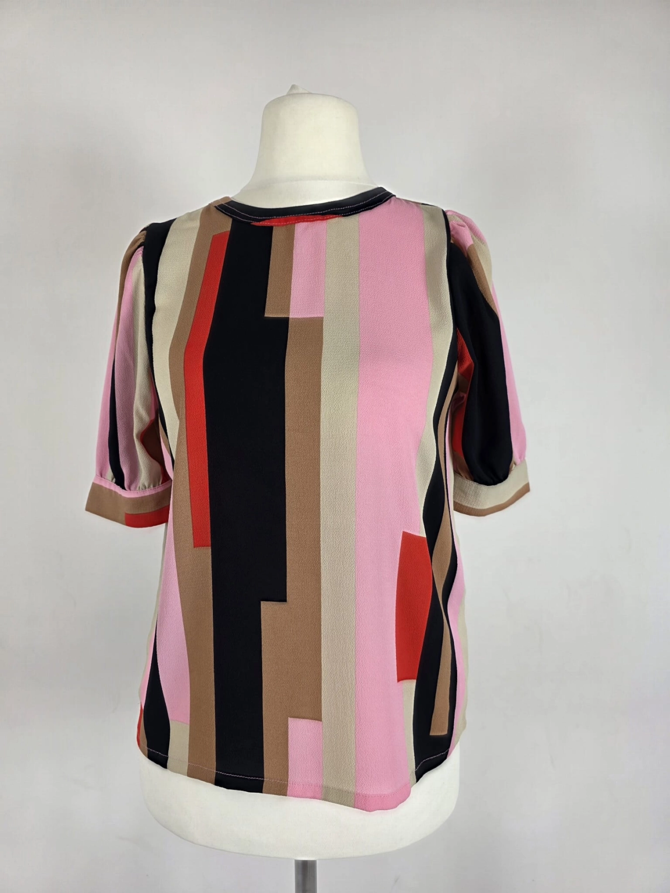 Oryginalna bluzka Vero Moda w różowo-brązowe geometryczne wzory, rozmiar XS, idealna do eleganckich i casualowych stylizacji.