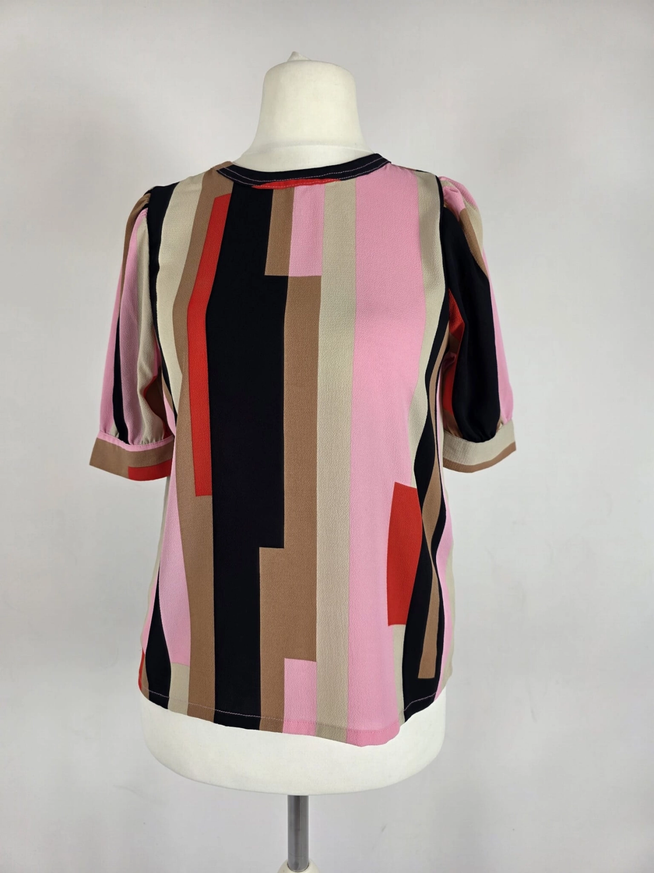 Oryginalna bluzka Vero Moda w różowo-brązowe geometryczne wzory, rozmiar XS, idealna do eleganckich i casualowych stylizacji.