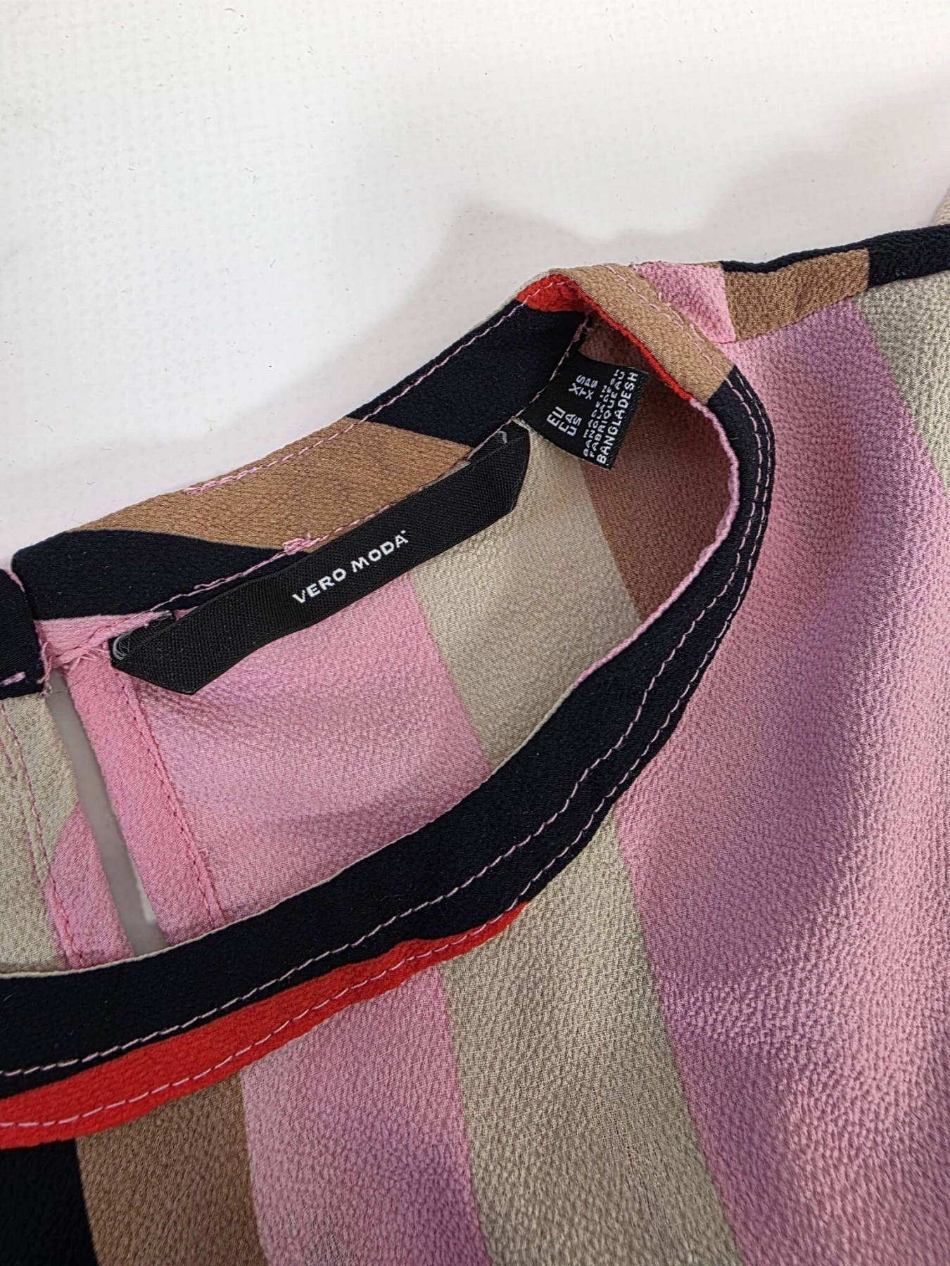 Oryginalna bluzka Vero Moda w różowo-brązowe geometryczne wzory, rozmiar XS, idealna do eleganckich i casualowych stylizacji.