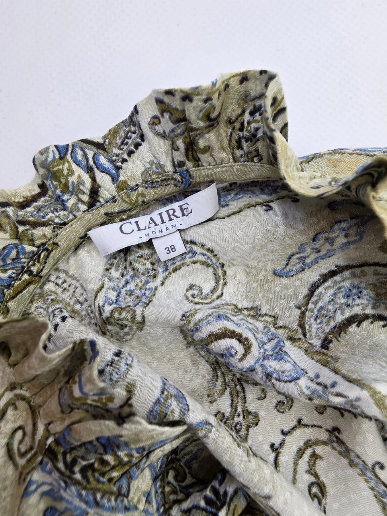 Elegancka sukienka midi marki Claire Woman wykonana w 100% z wiskozy, zdobiona wzorem paisley z podkreśloną talią i ozdobną stójką.