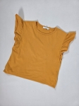 Modna stylizacja warstwowa: kremowy ażurowy sweter Vero Moda, pomarańczowy t-shirt z falbankami Costes oraz czarna sukienka jeansowa Only
