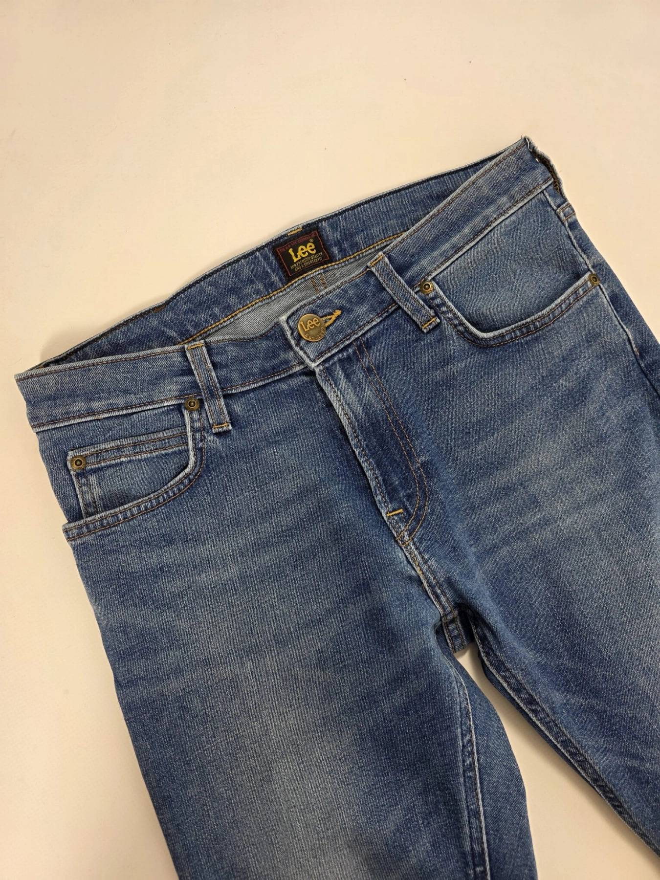 Markowa stylizacja damska z jeansami Lee, beżowym t-shirtem Simple oraz wzorzystą bluzką Soyaconcept w stylu premium