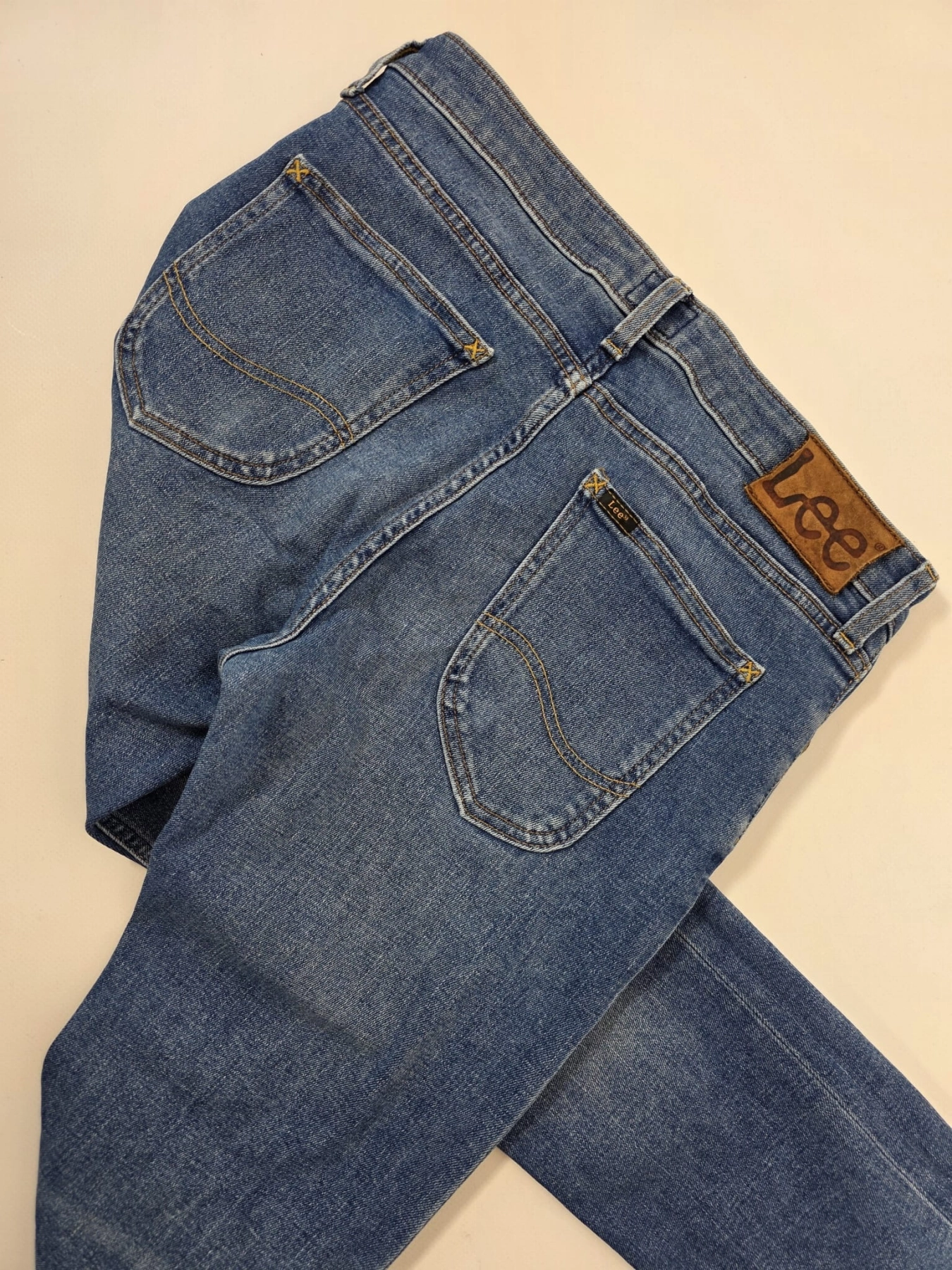 Markowa stylizacja damska z jeansami Lee, beżowym t-shirtem Simple oraz wzorzystą bluzką Soyaconcept w stylu premium