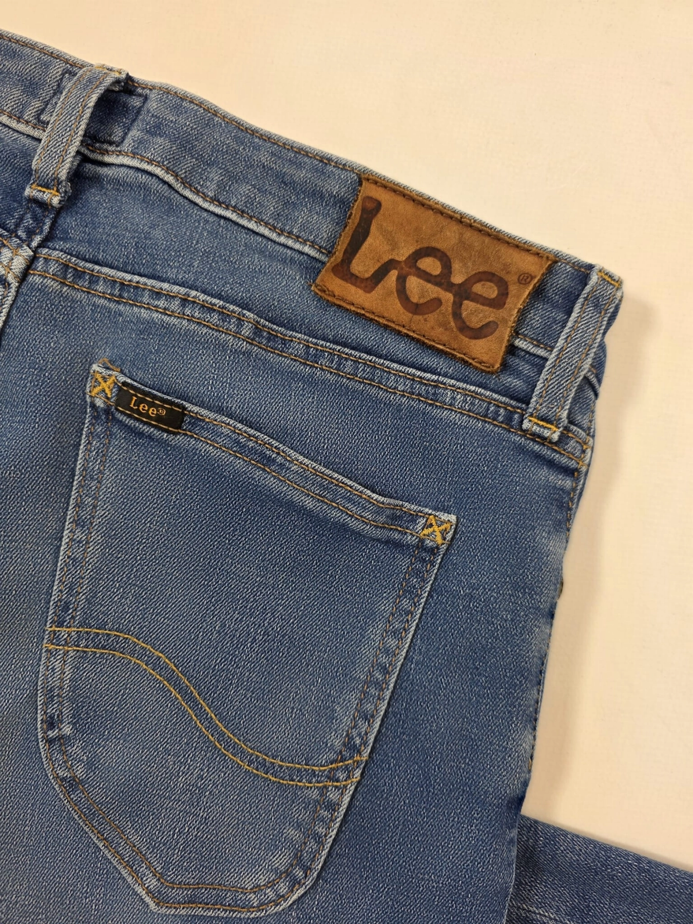 Markowa stylizacja damska z jeansami Lee, beżowym t-shirtem Simple oraz wzorzystą bluzką Soyaconcept w stylu premium
