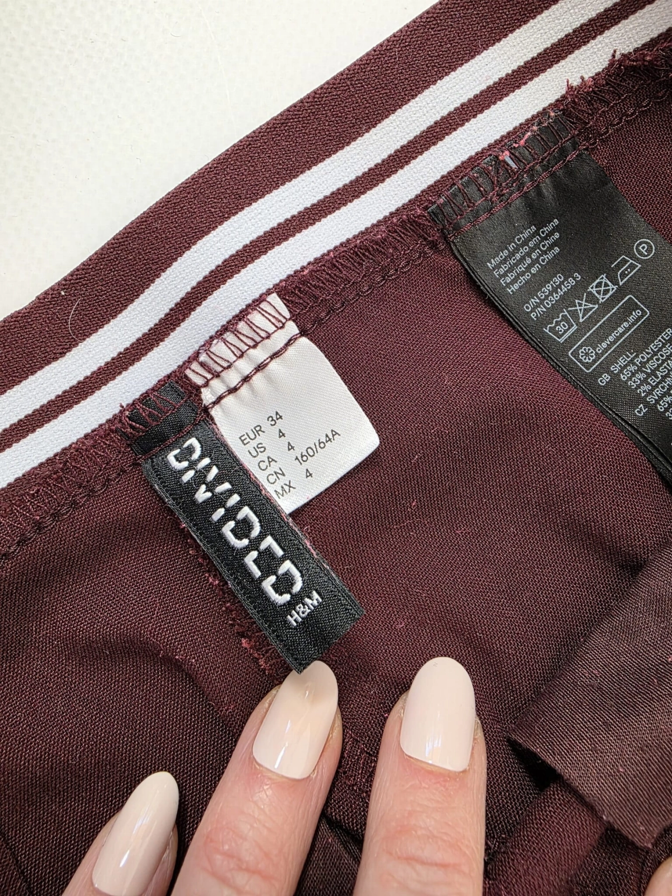 Damska stylizacja premium składająca się z różowej koszuli w paski Zara oraz bordowych spodni HM z wysokim stanem