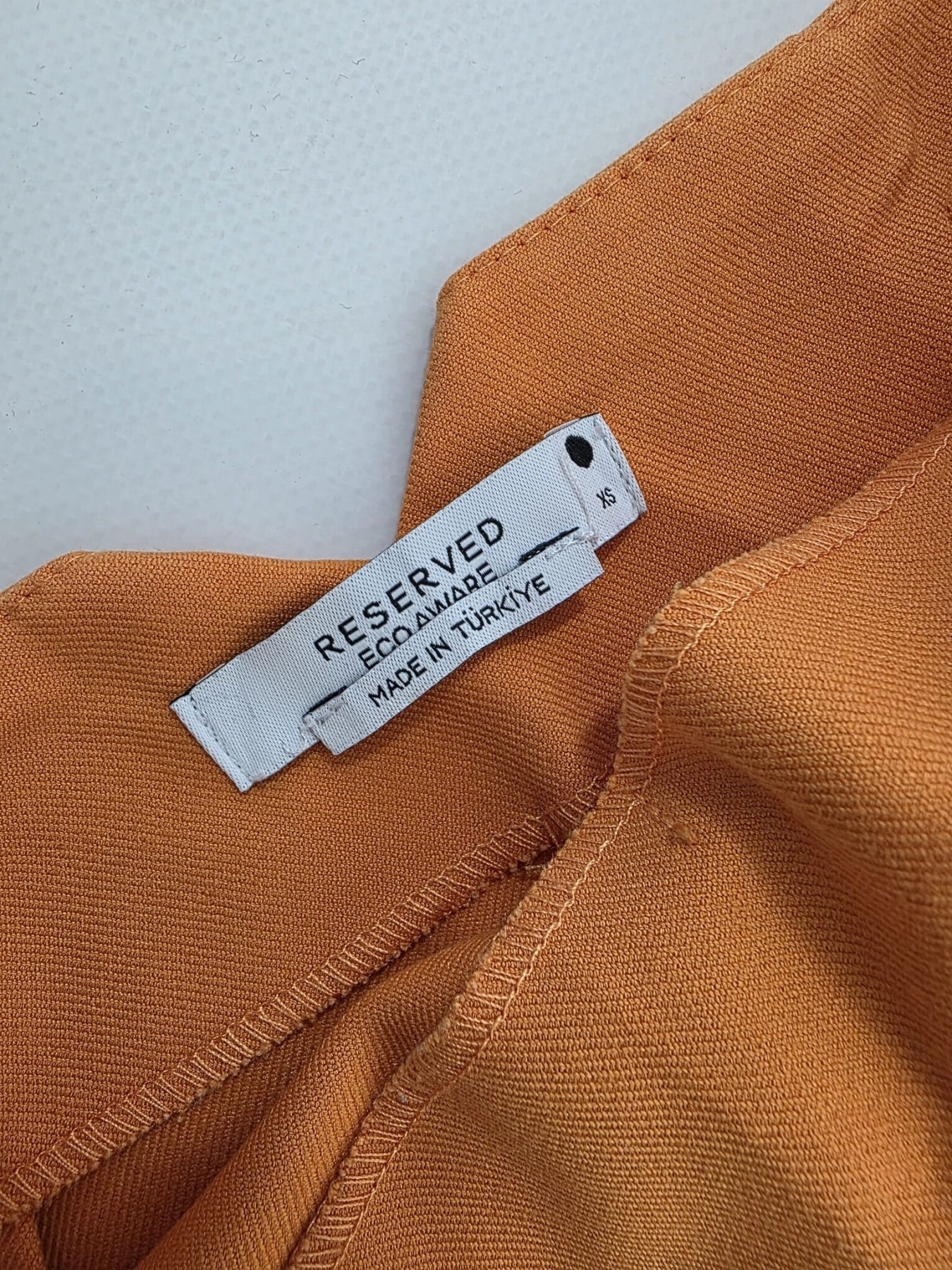 Stylowy zestaw damski składający się z prążkowanej bluzki Massimo Dutti oraz eleganckich pomarańczowych spodni Reserved z wysokim stanem
