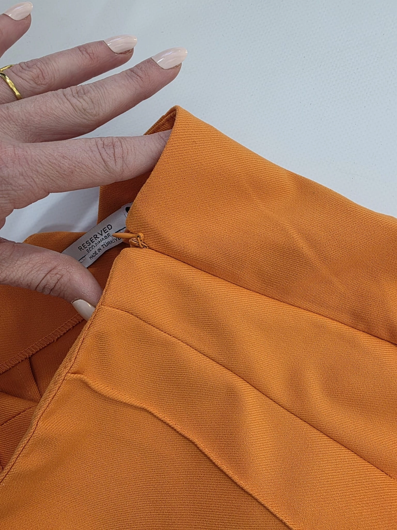 Stylowy zestaw damski składający się z prążkowanej bluzki Massimo Dutti oraz eleganckich pomarańczowych spodni Reserved z wysokim stanem