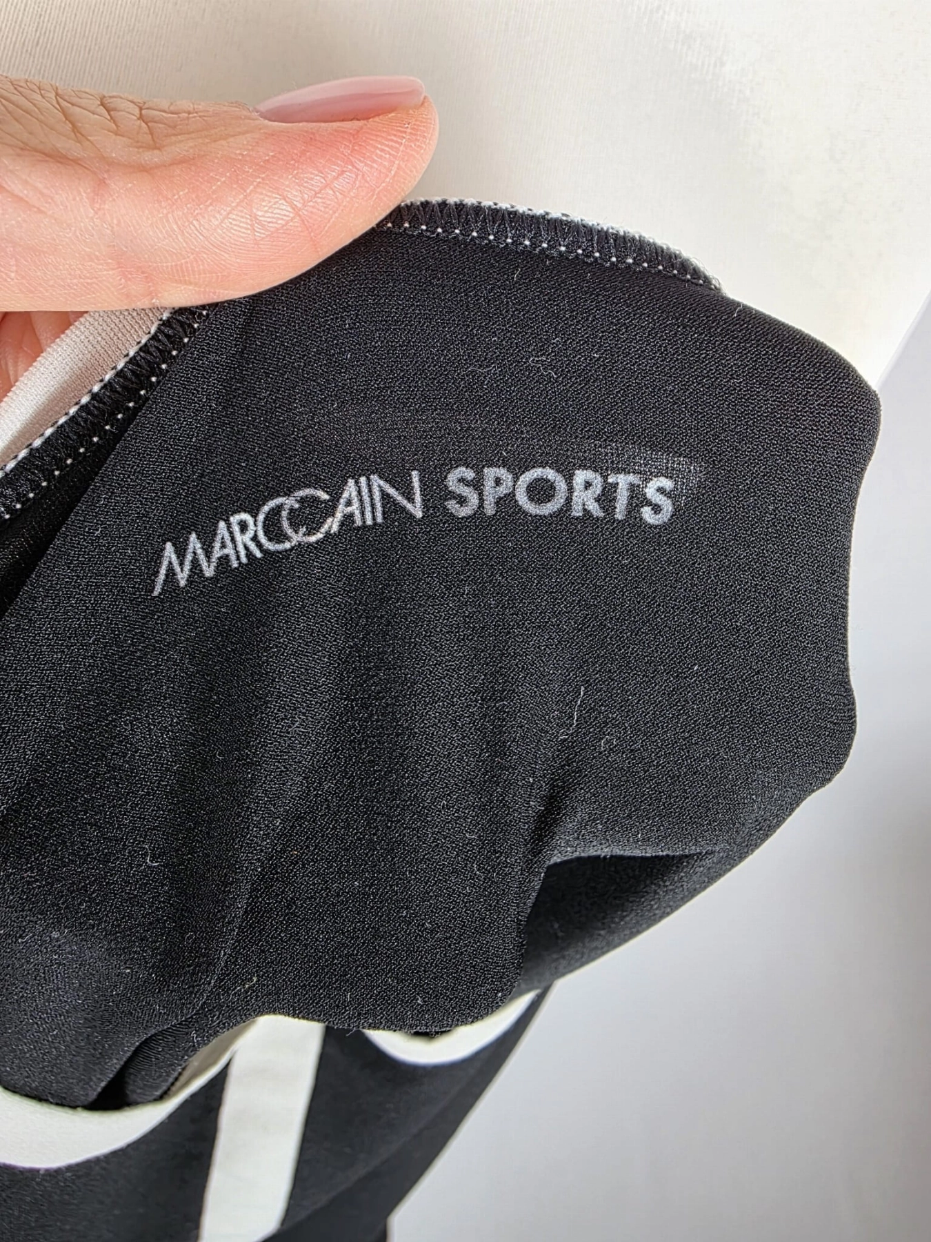 Czarna damska bluzka MarcCain Sports z długim rękawem i kontrastowym jasnym pasem, wykonana z elastycznej dzianiny premium