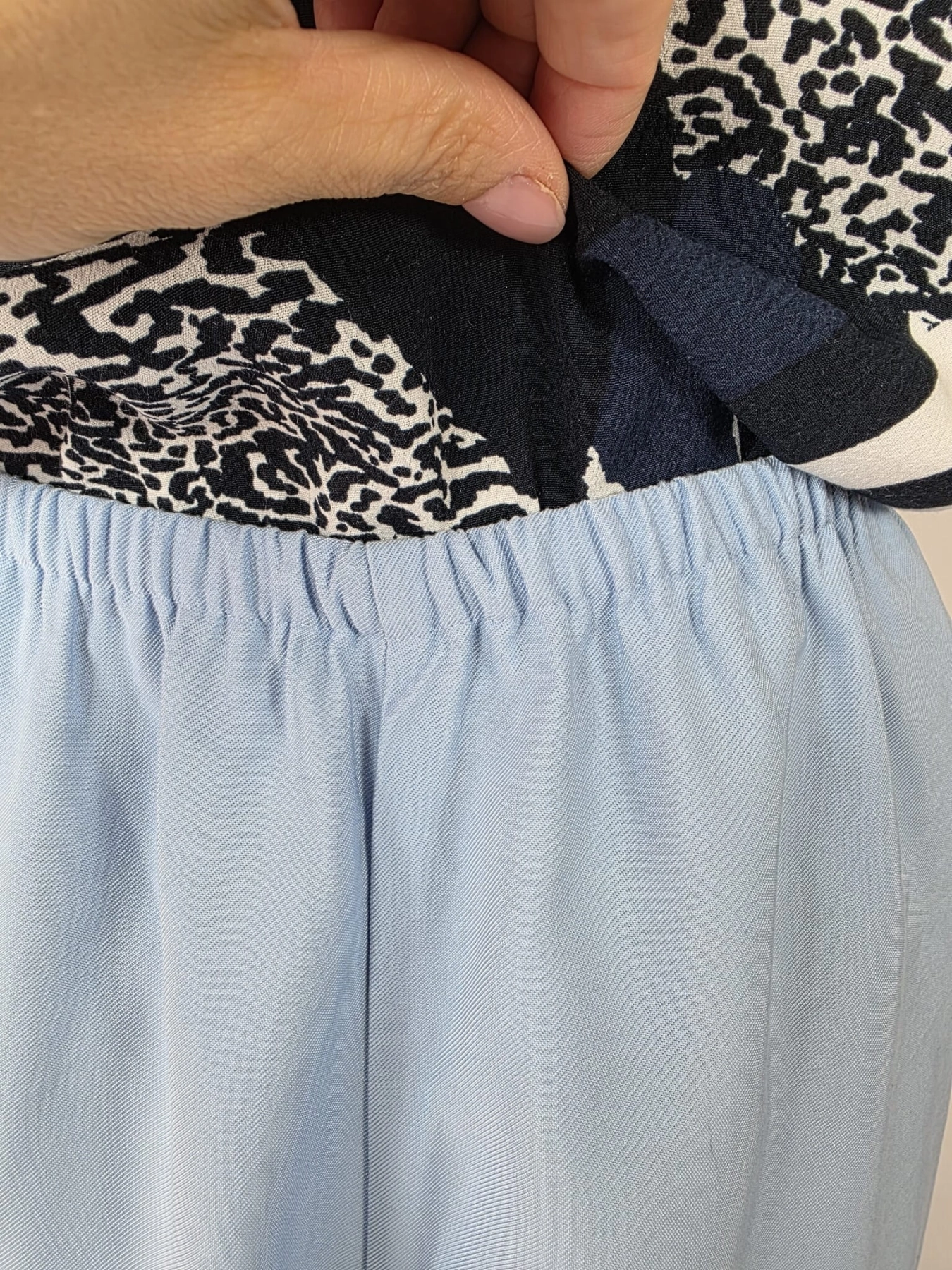Stylowy damski komplet składający się z wiskozowej bluzki Saint Tropez w abstrakcyjny wzór oraz błękitnych spodni Reserved z wysokim stanem