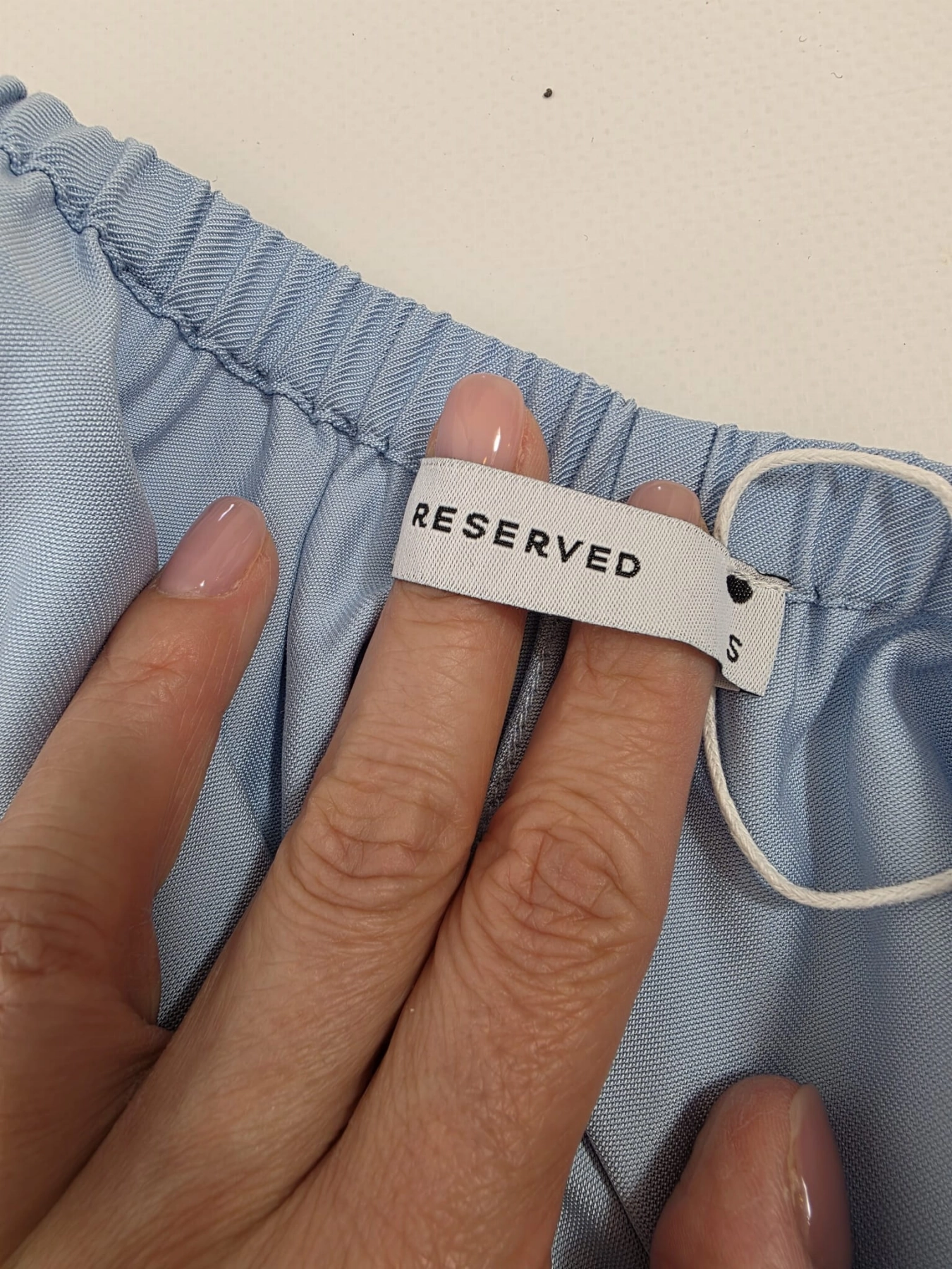 Stylowy damski komplet składający się z wiskozowej bluzki Saint Tropez w abstrakcyjny wzór oraz błękitnych spodni Reserved z wysokim stanem