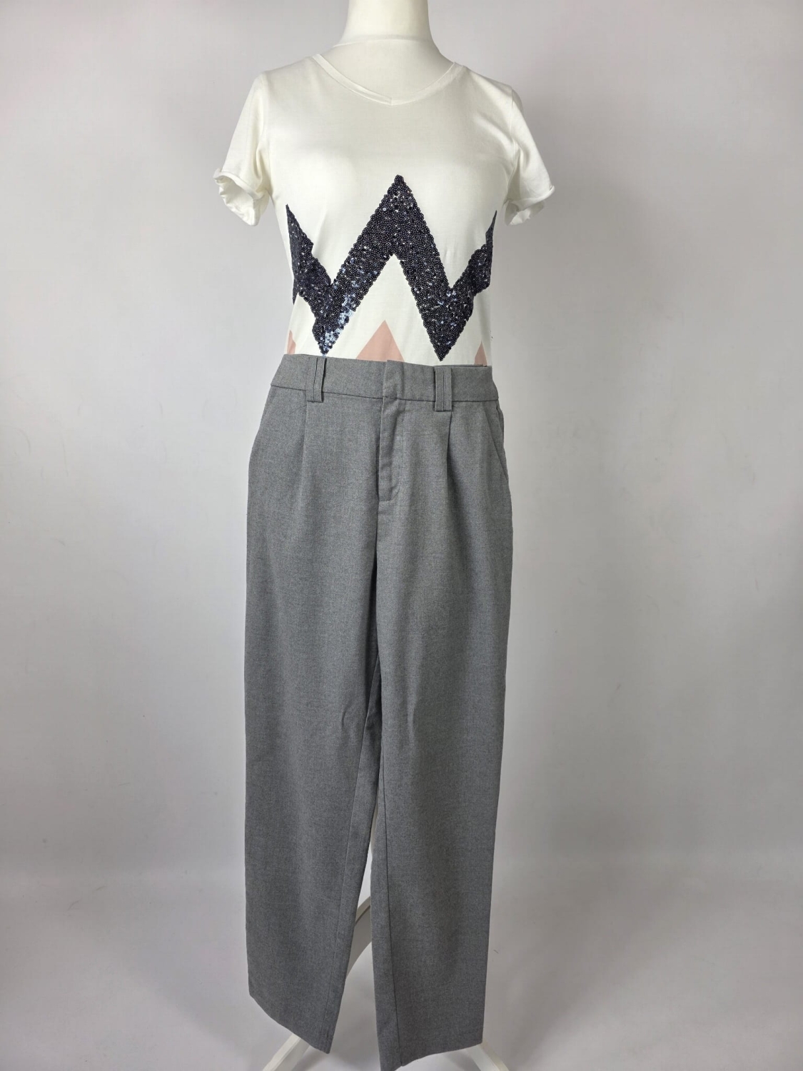 Stylowy zestaw damski składający się z szarych cygaretek House z wysokim stanem oraz białego t-shirtu Saint Tropez z cekinowym wzorem