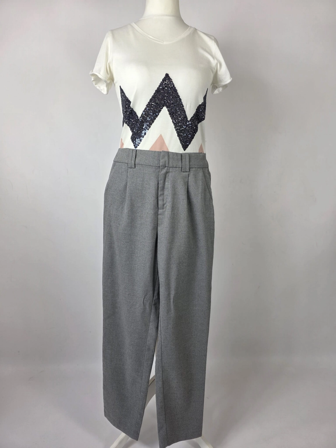 Stylowy zestaw damski składający się z szarych cygaretek House z wysokim stanem oraz białego t-shirtu Saint Tropez z cekinowym wzorem