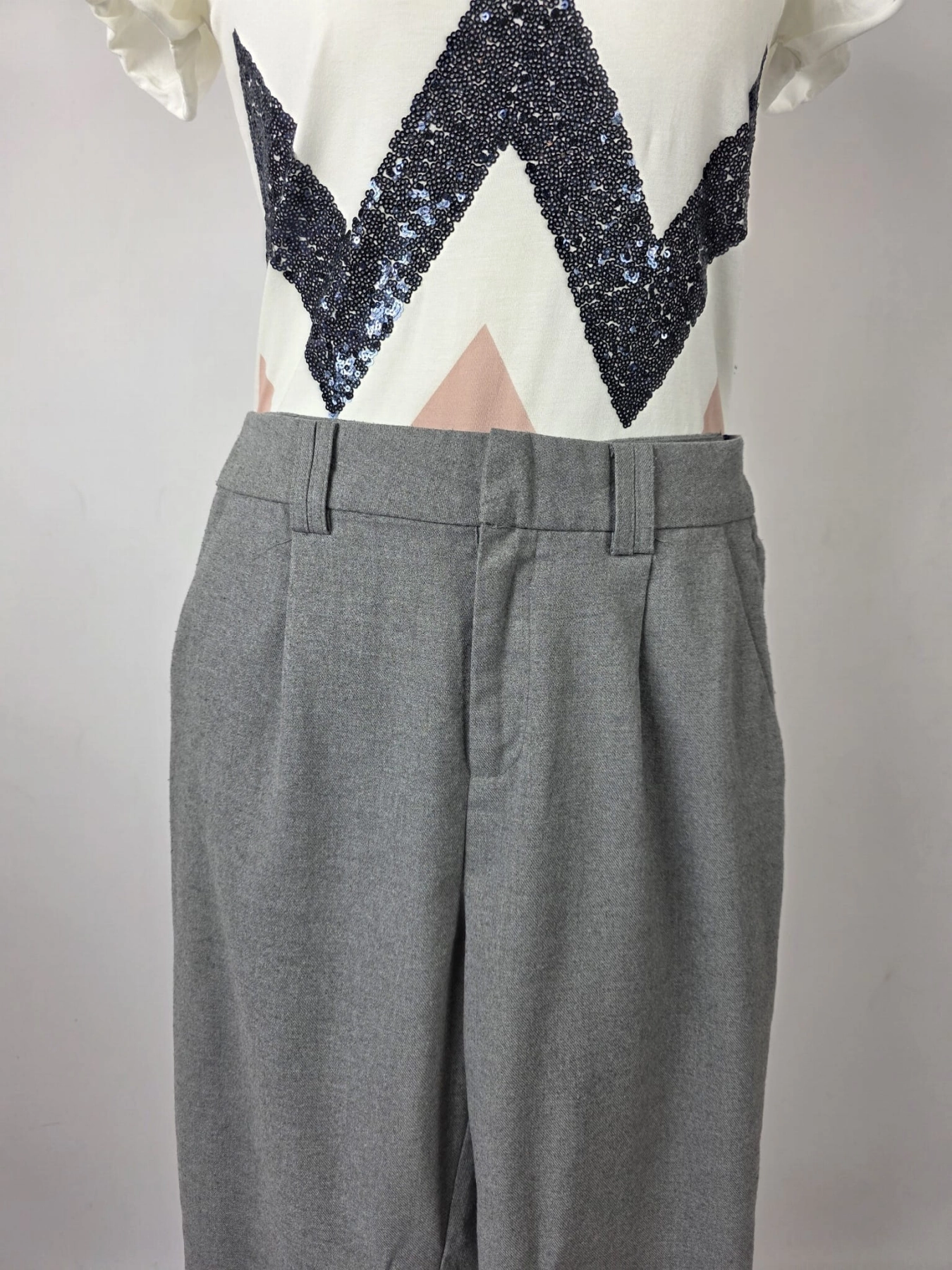 Stylowy zestaw damski składający się z szarych cygaretek House z wysokim stanem oraz białego t-shirtu Saint Tropez z cekinowym wzorem