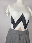 Stylowy zestaw damski składający się z szarych cygaretek House z wysokim stanem oraz białego t-shirtu Saint Tropez z cekinowym wzorem
