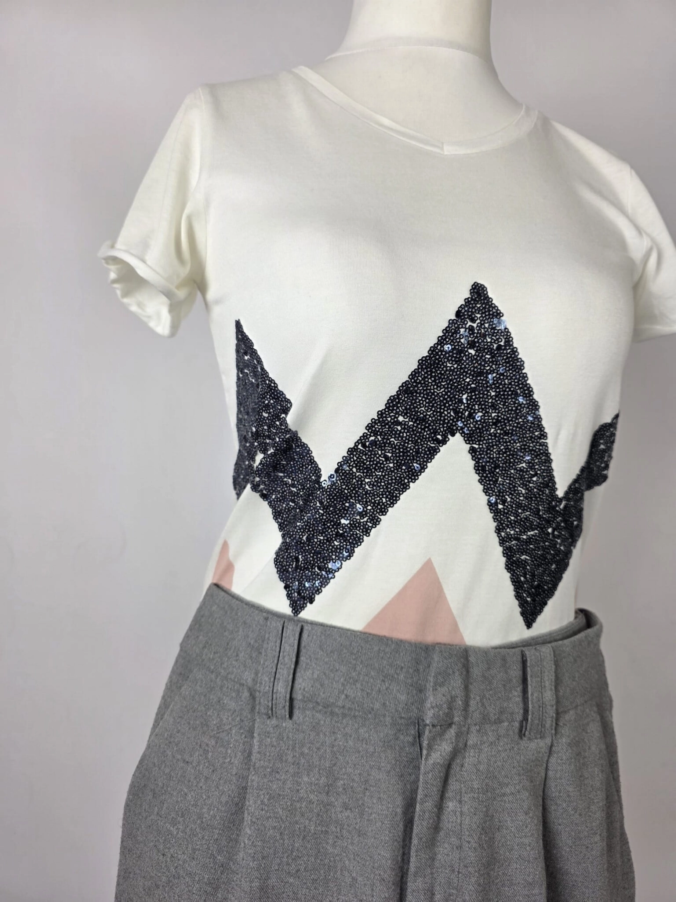Stylowy zestaw damski składający się z szarych cygaretek House z wysokim stanem oraz białego t-shirtu Saint Tropez z cekinowym wzorem