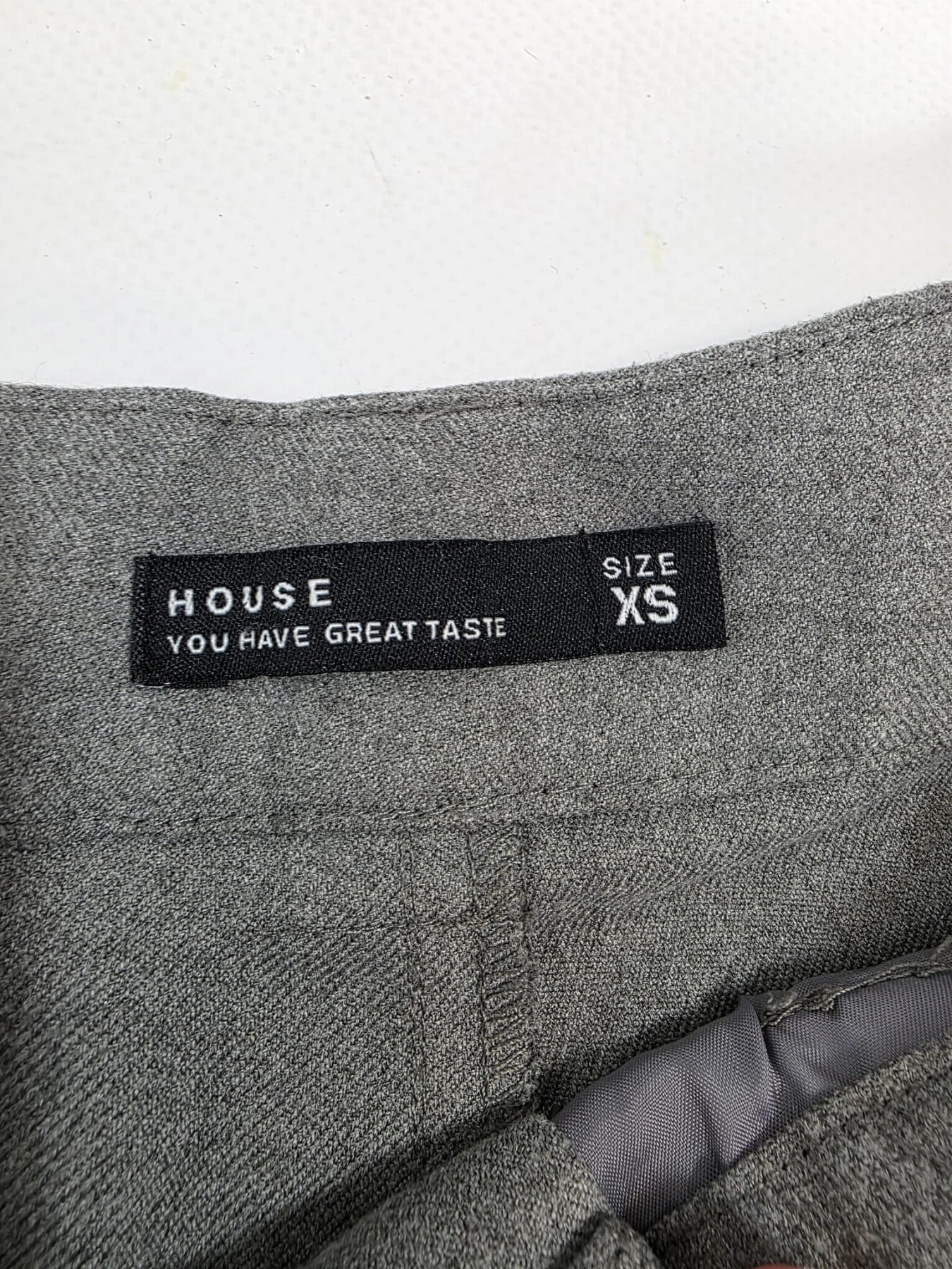 Stylowy zestaw damski składający się z szarych cygaretek House z wysokim stanem oraz białego t-shirtu Saint Tropez z cekinowym wzorem