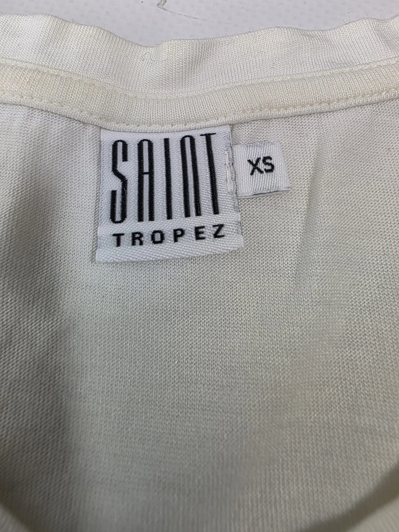 Stylowy zestaw damski składający się z szarych cygaretek House z wysokim stanem oraz białego t-shirtu Saint Tropez z cekinowym wzorem