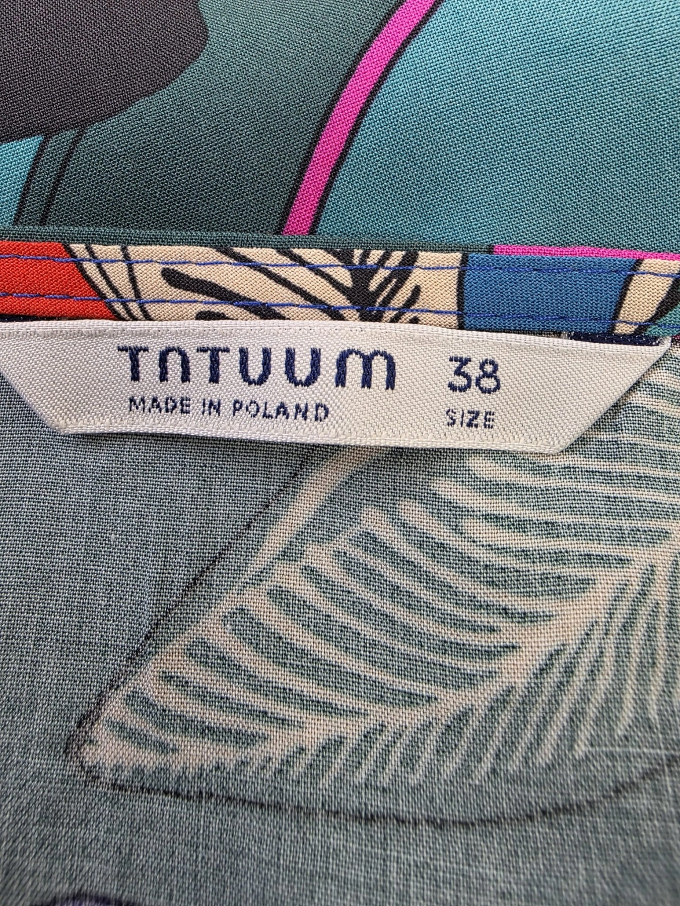 Damska bluzka Tatuum w kolorowe kwiaty, rozmiar 38, o swobodnym kroju z rękawem 3/4 i dekoltem w łódkę