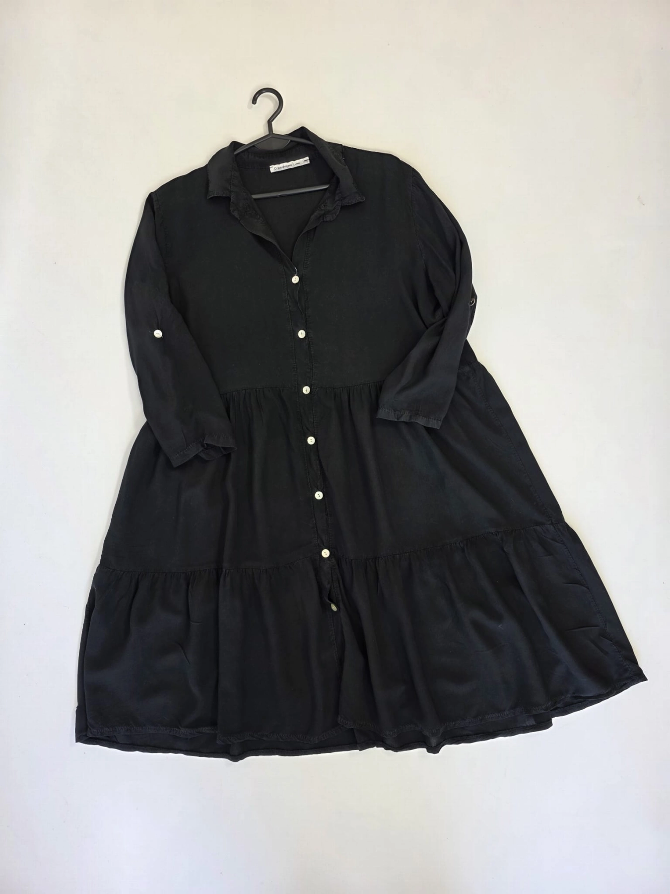 Czarny komplet premium składający się z kaskadowej sukienki koszulowej oraz sportowej bluzy Nike typu crop idealnie wpisuje się w najnowsze trendy mody casualowej