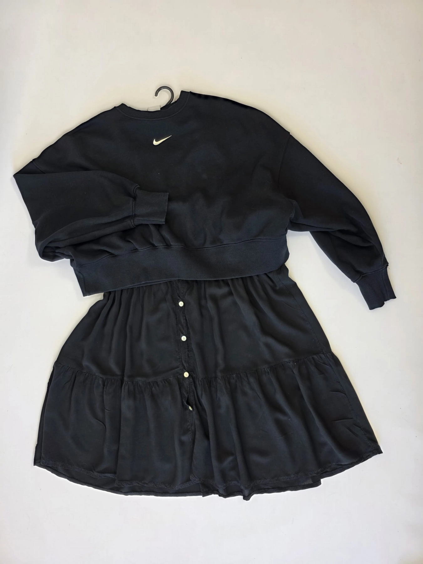 Czarny komplet premium składający się z kaskadowej sukienki koszulowej oraz sportowej bluzy Nike typu crop idealnie wpisuje się w najnowsze trendy mody casualowej