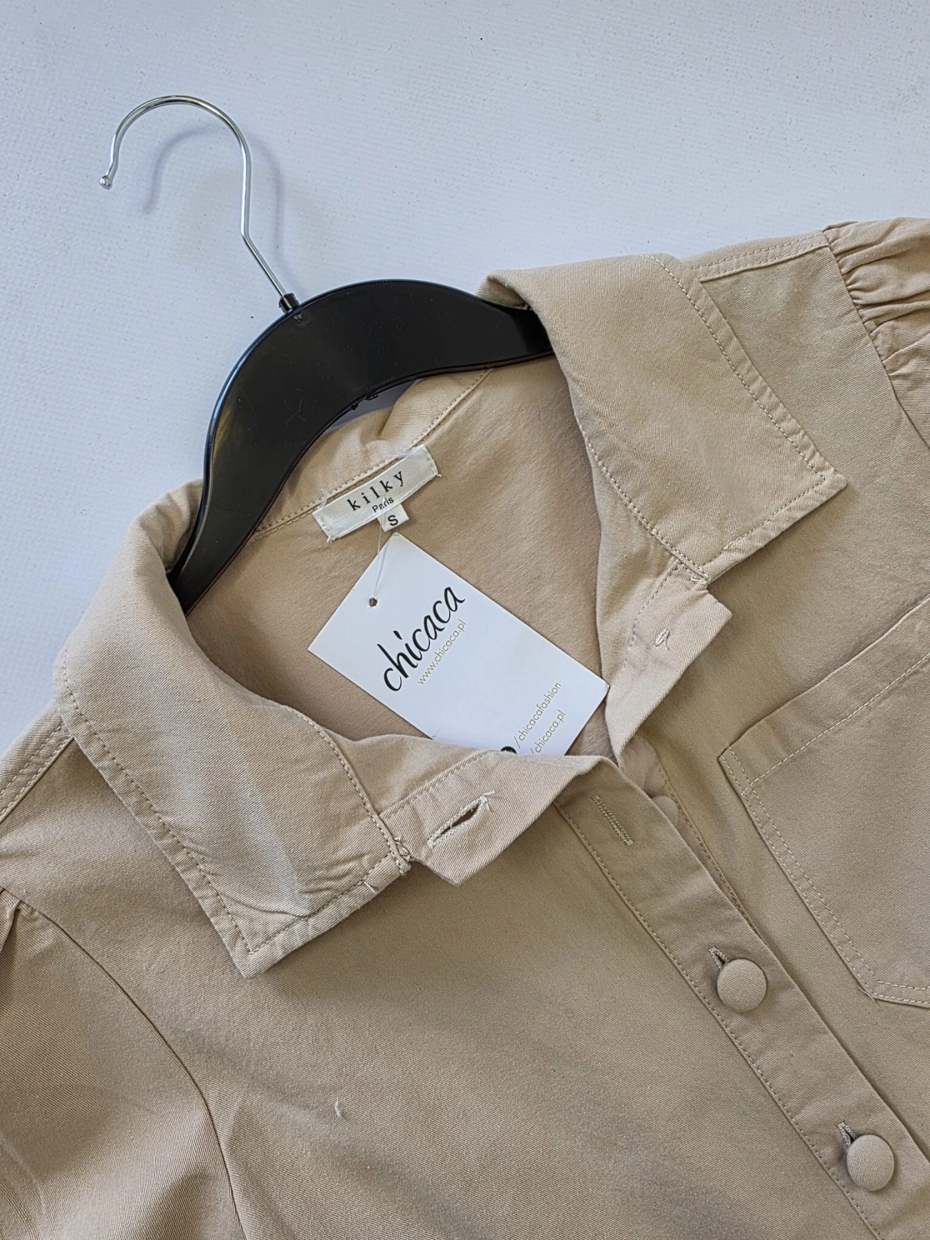 Damski bawełniany kombinezon Kilky Paris w kolorze beżowym z paskiem w talii i ozdobnymi nogawkami, idealny do casualowych i eleganckich letnich stylizacji premium