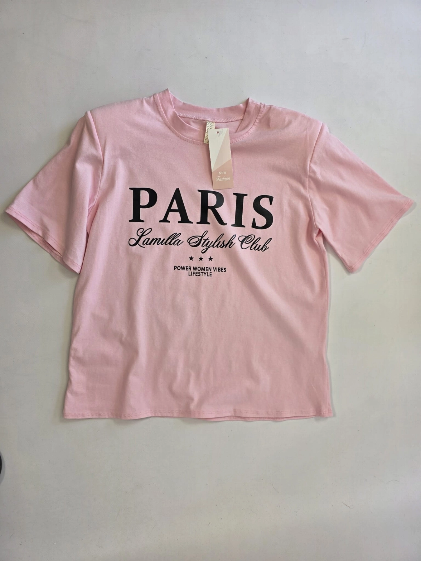 Różowy t-shirt z nadrukiem Paris oraz włoskie zielone spodnie wide leg z wysokim stanem tworzą modną i wygodną stylizację damską w duchu premium vintage