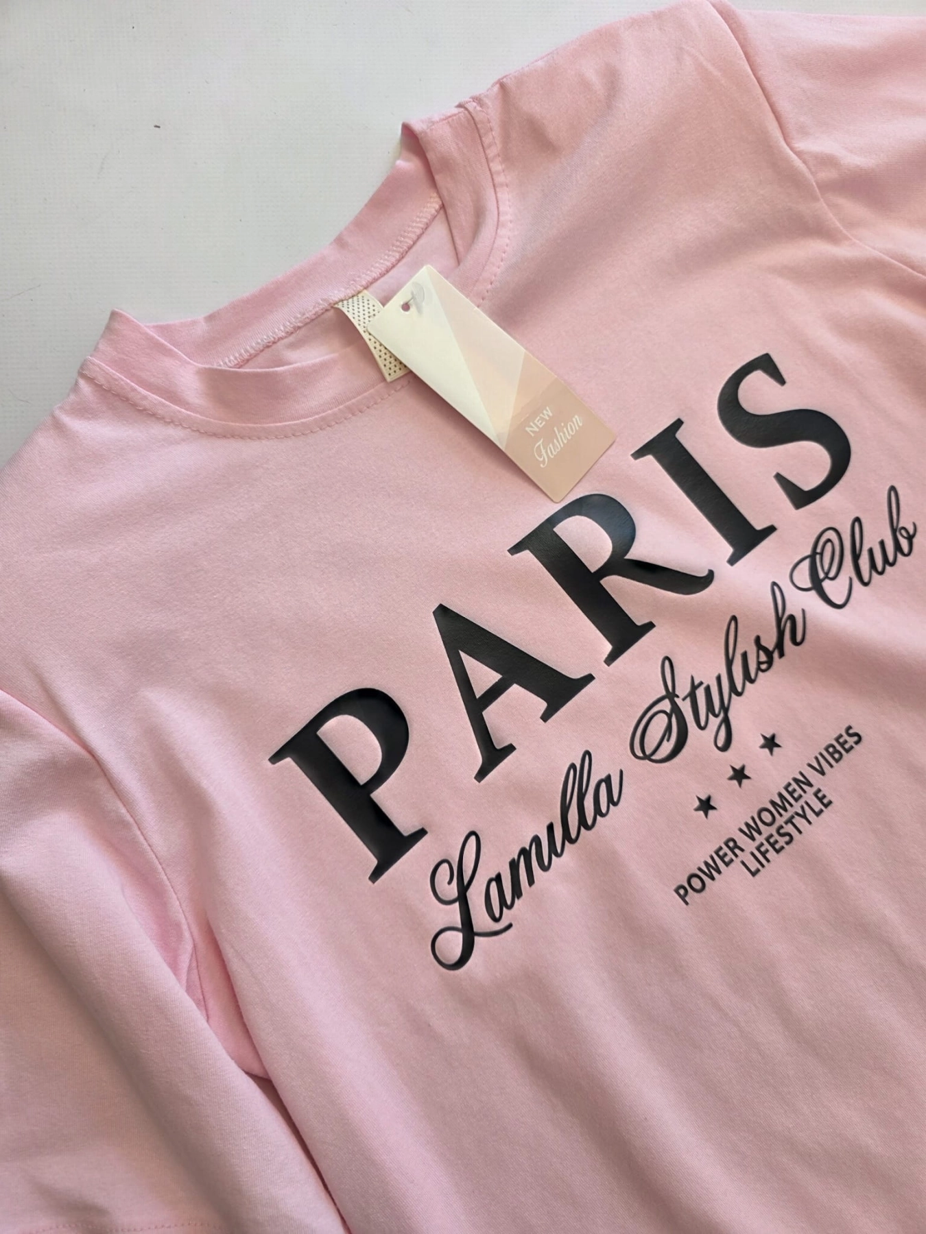 Różowy t-shirt z nadrukiem Paris oraz włoskie zielone spodnie wide leg z wysokim stanem tworzą modną i wygodną stylizację damską w duchu premium vintage