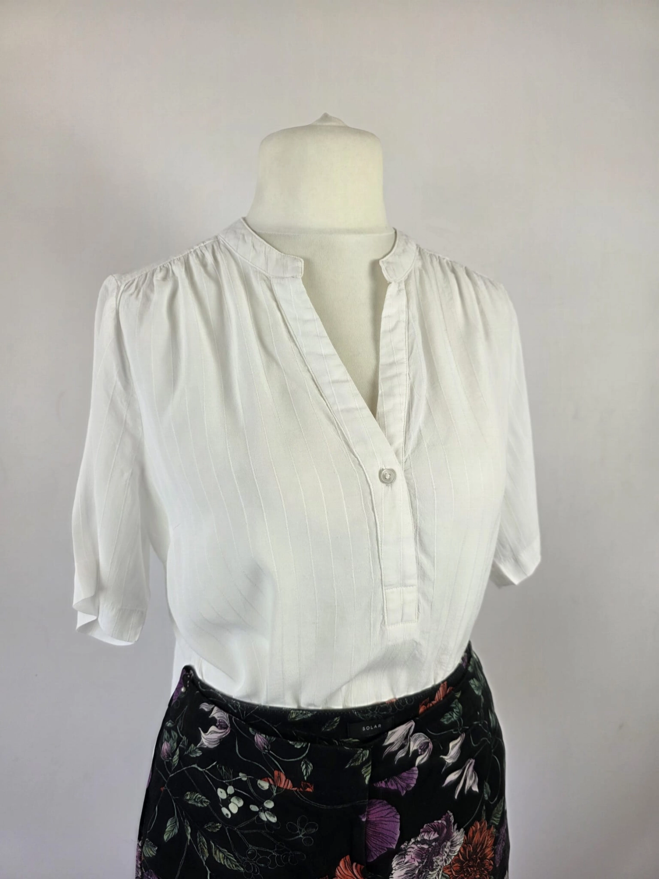 Ekskluzywny komplet damski składający się z kwiecistych spodni Solar, eleganckiej białej bluzki Selected Femme oraz lekkiej kurtki, idealny na wyjątkowe okazje i stylowe wyjścia
