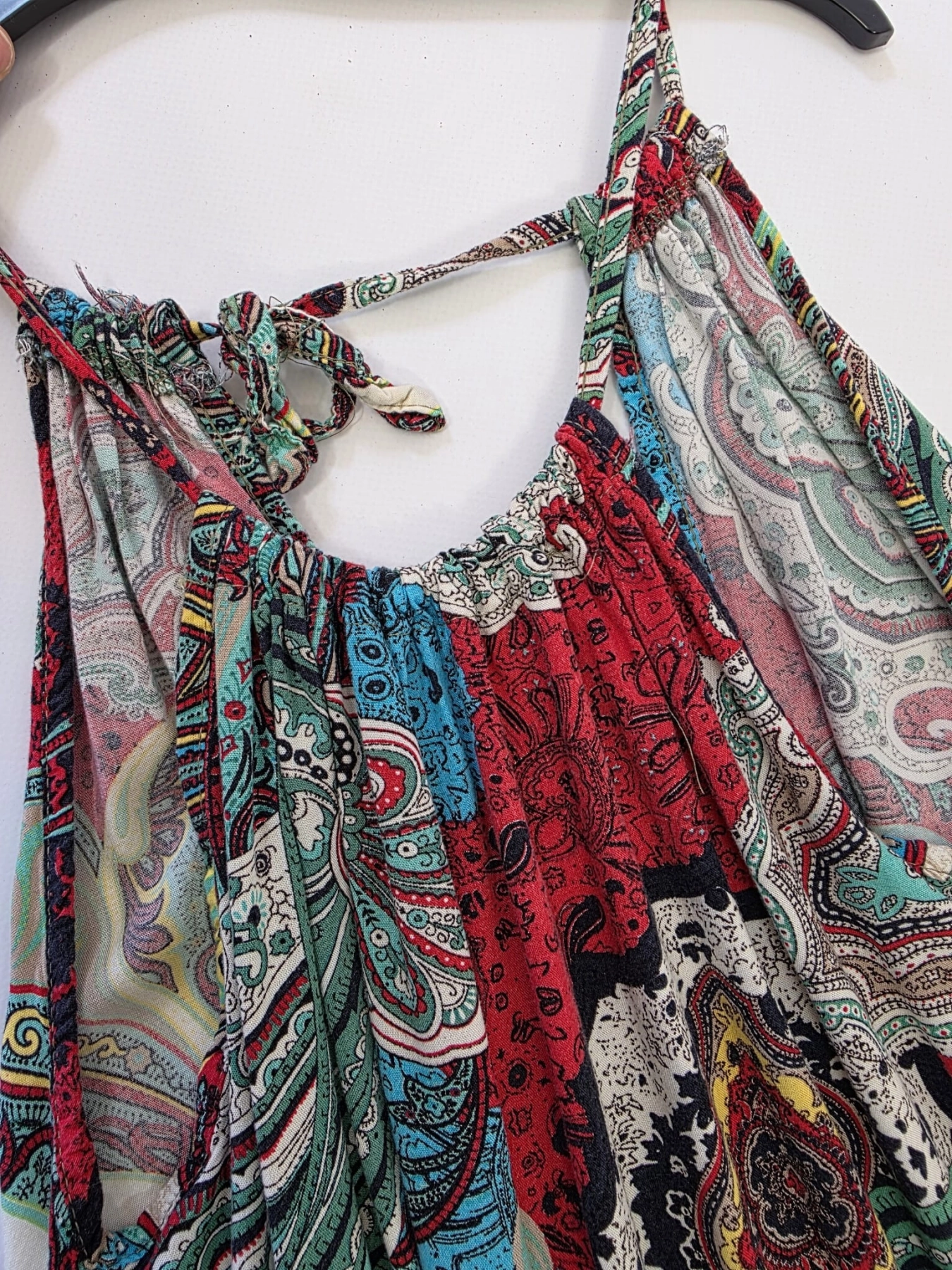 Kolorowa sukienka damska mini w orientalny wzór paisley, z wiązanym dekoltem typu halter i odkrytymi plecami, idealna na lato w stylu boho premium