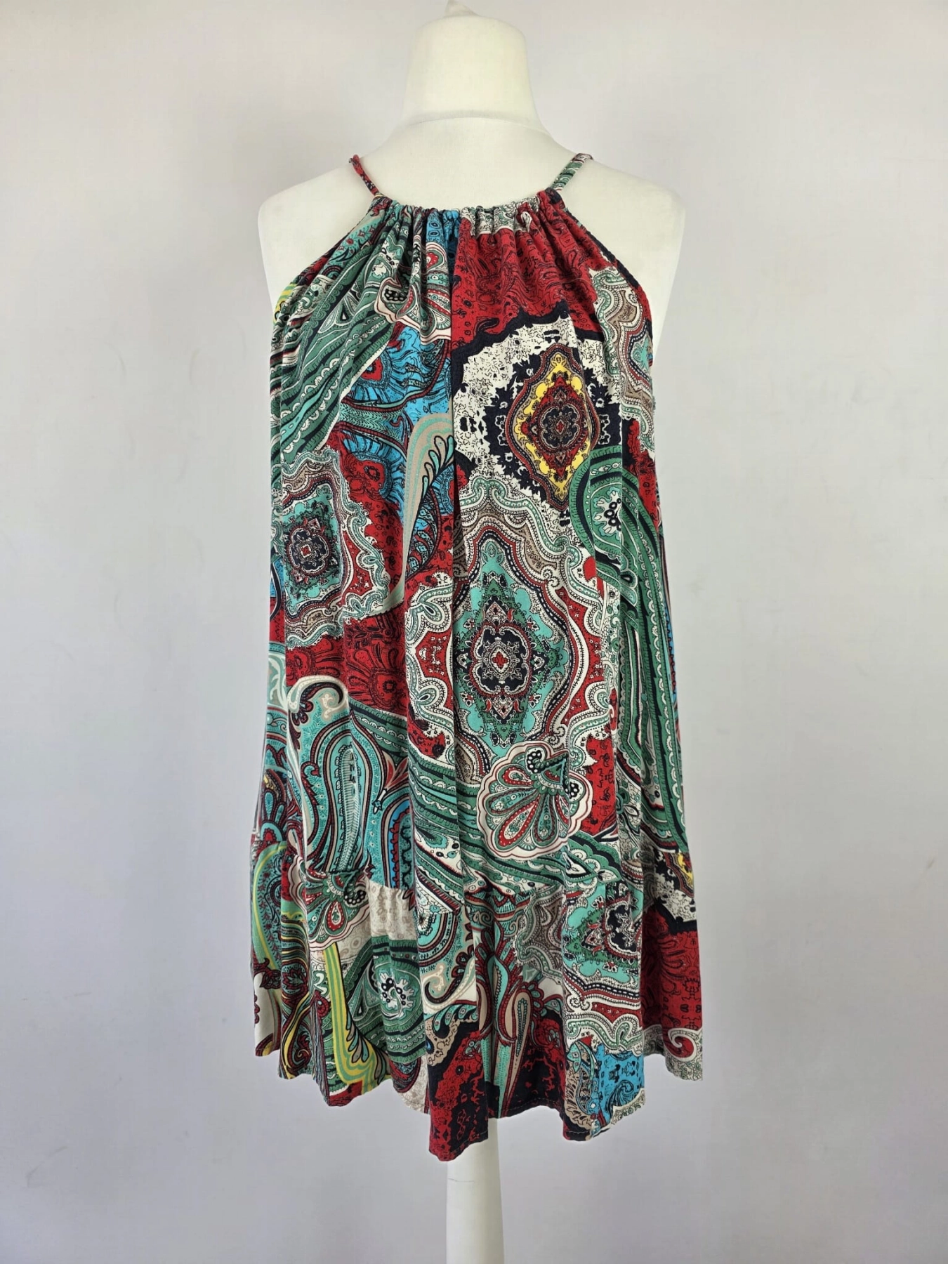 Kolorowa sukienka damska mini w orientalny wzór paisley, z wiązanym dekoltem typu halter i odkrytymi plecami, idealna na lato w stylu boho premium