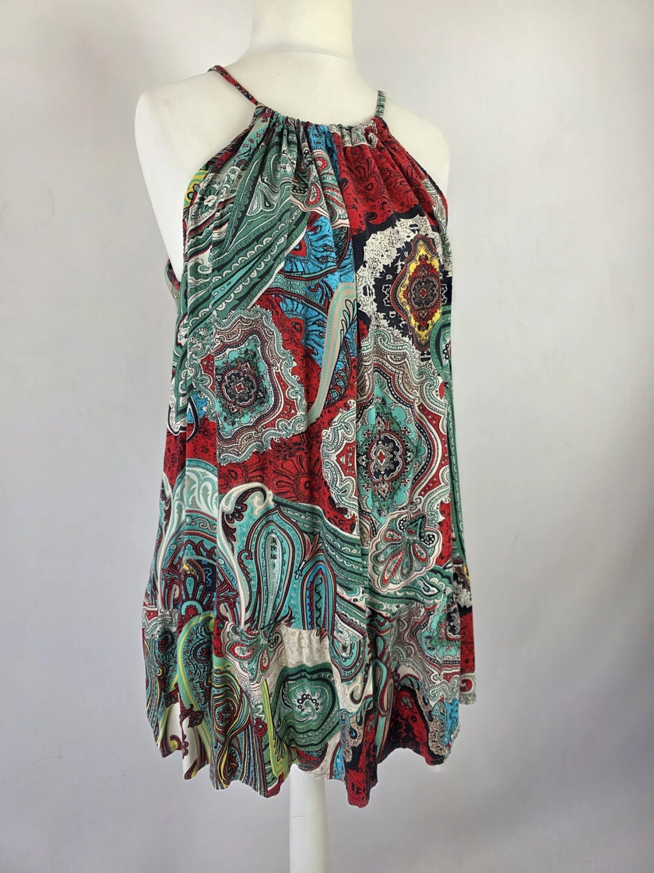 Kolorowa sukienka damska mini w orientalny wzór paisley, z wiązanym dekoltem typu halter i odkrytymi plecami, idealna na lato w stylu boho premium