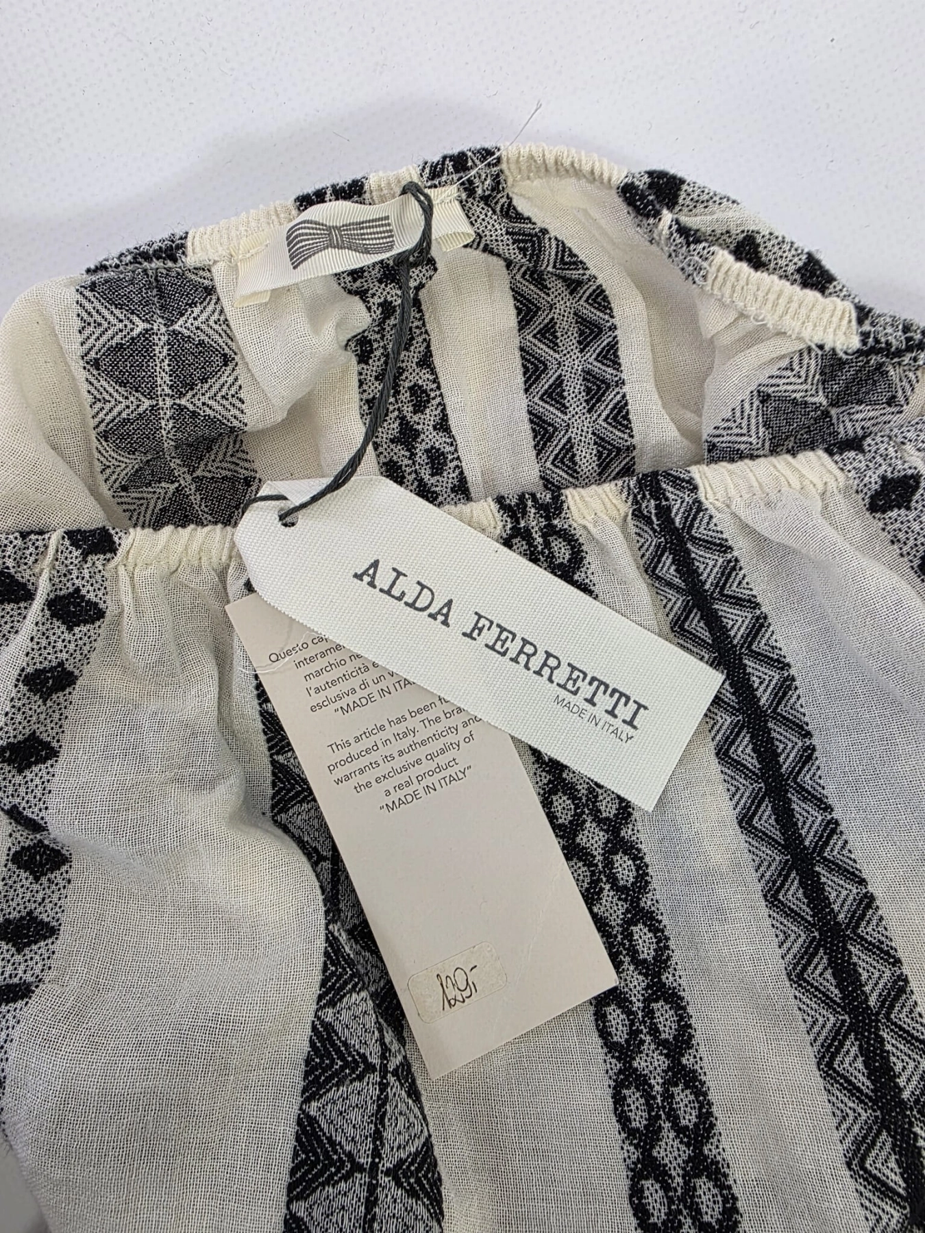 Włoska sukienka asymetryczna Alda Ferretti wykonana w 100% z bawełny to idealna, lekka sukienka na lato w stylu boho, która doskonale podkreśla talię i eksponuje ramiona