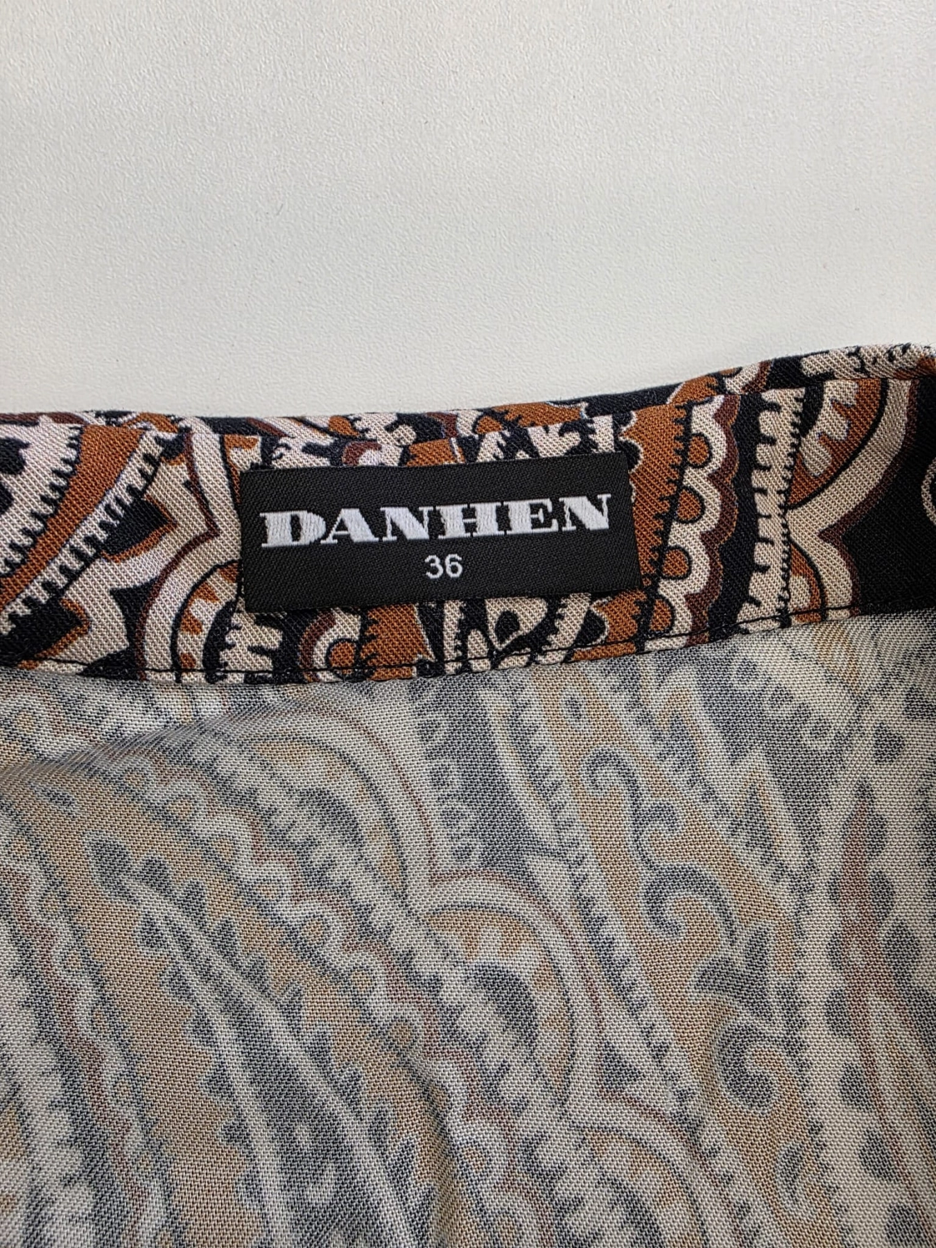 Elegancka wiskozowa sukienka midi marki Danhen w brązowy wzór paisley, z kołnierzykiem i rozcięciami po bokach, idealna do stylizacji biurowych i casualowych premium