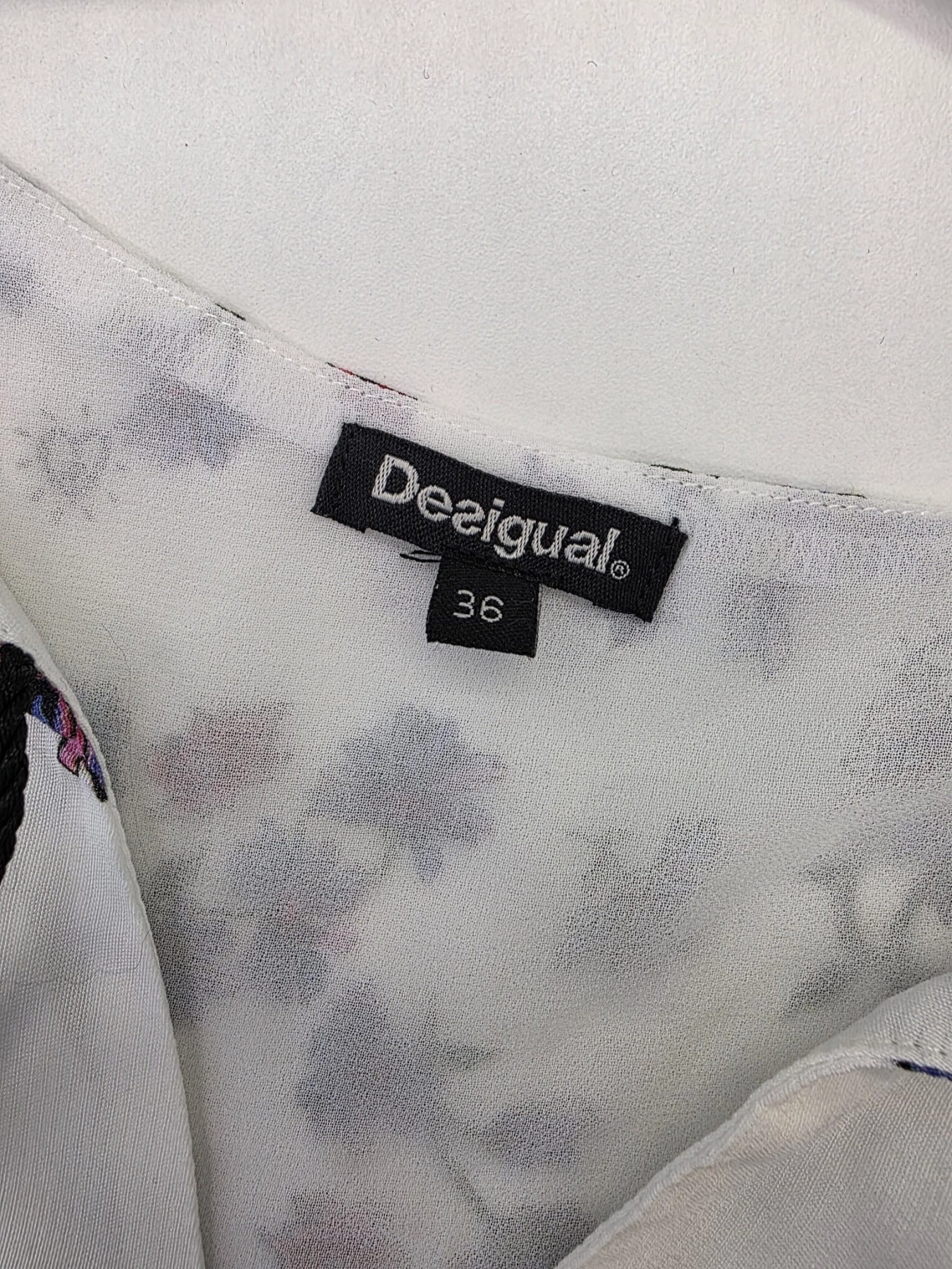 Oryginalna sukienka mini Desigual w rozmiarze 36, ozdobiona unikalnym wzorem boho z motywem kwiatów i pacyfki, wykonana z wiskozy