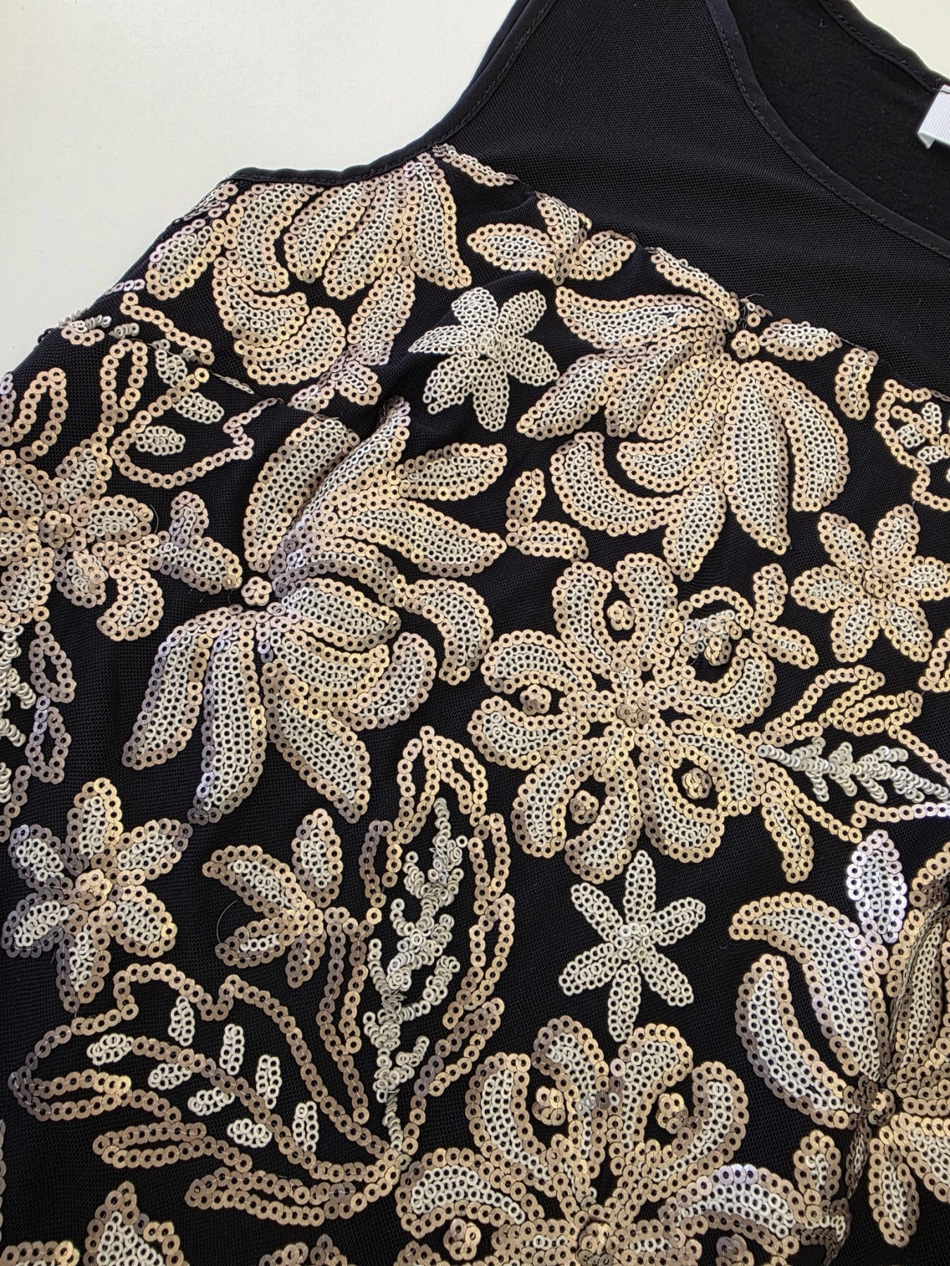 Ekskluzywna stylizacja wieczorowa premium składająca się z błyszczącej bluzki w cekiny marki Savida oraz eleganckich, jasnych spodni palazzo z wysokim stanem i paskiem