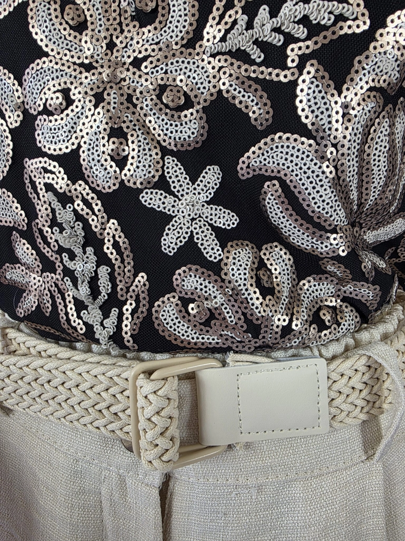 Ekskluzywna stylizacja wieczorowa premium składająca się z błyszczącej bluzki w cekiny marki Savida oraz eleganckich, jasnych spodni palazzo z wysokim stanem i paskiem