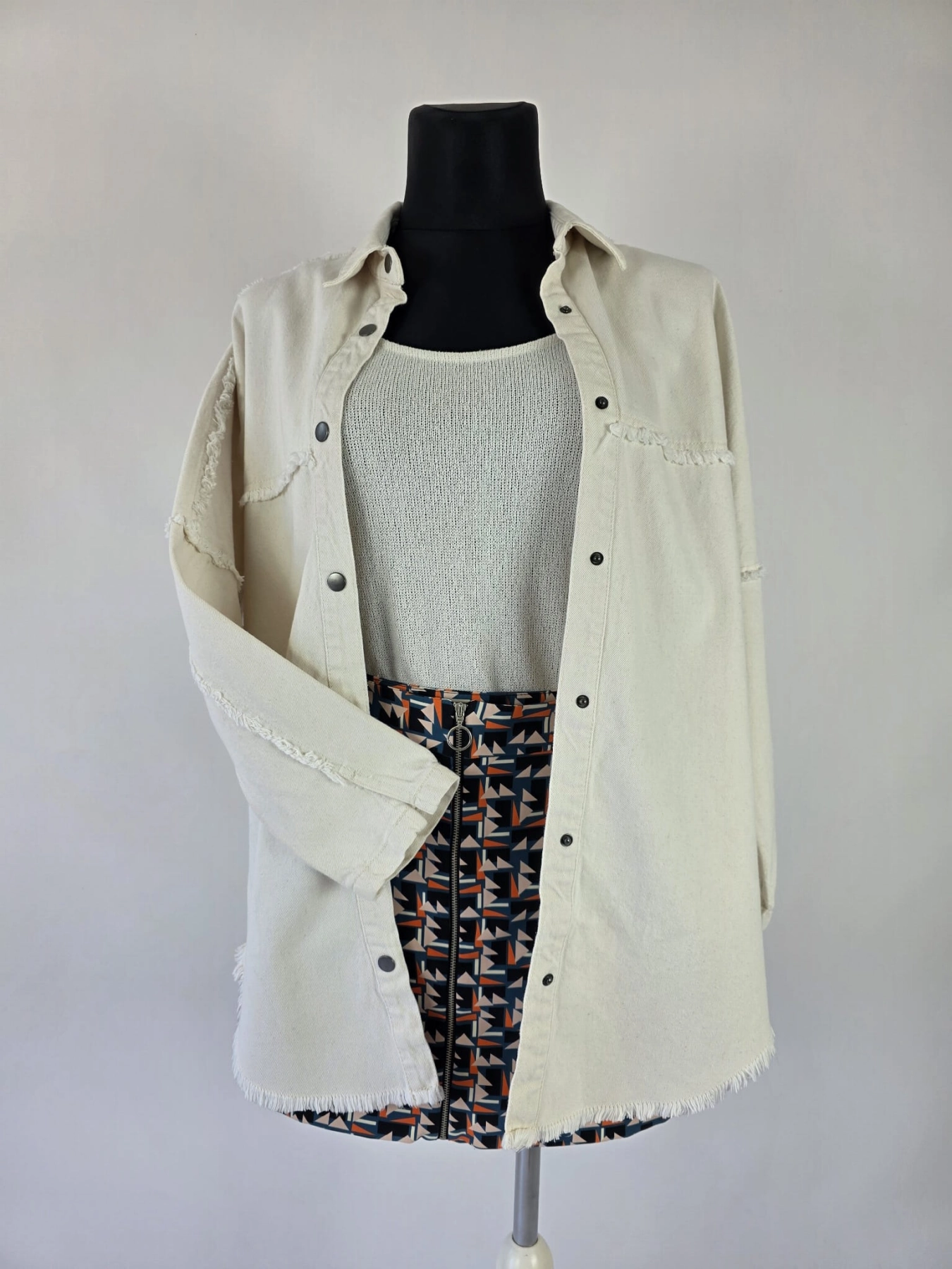 Stylowy komplet damski premium składający się ze spódnicy mini Promod w geometryczne wzory, kremowego topu dzianinowego Tezenis oraz jeansowej katany oversize marki JDY