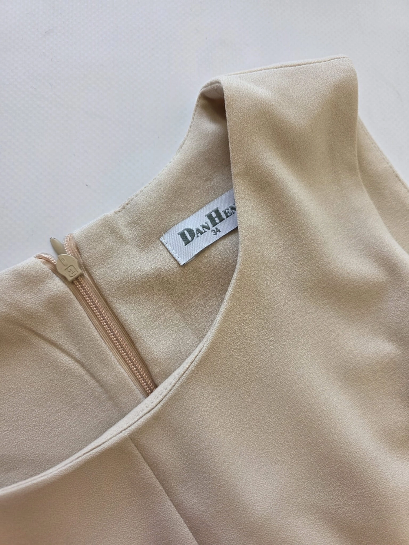 Beżowa sukienka mini marki DanHen z elegancką falbaną i krytym zamkiem to idealna propozycja premium z odzieży używanej na wyjątkowe okazje