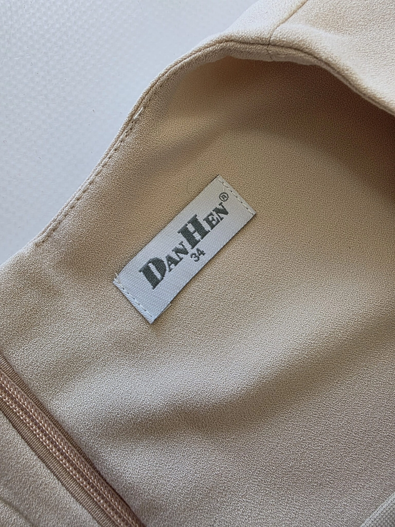 Beżowa sukienka mini marki DanHen z elegancką falbaną i krytym zamkiem to idealna propozycja premium z odzieży używanej na wyjątkowe okazje
