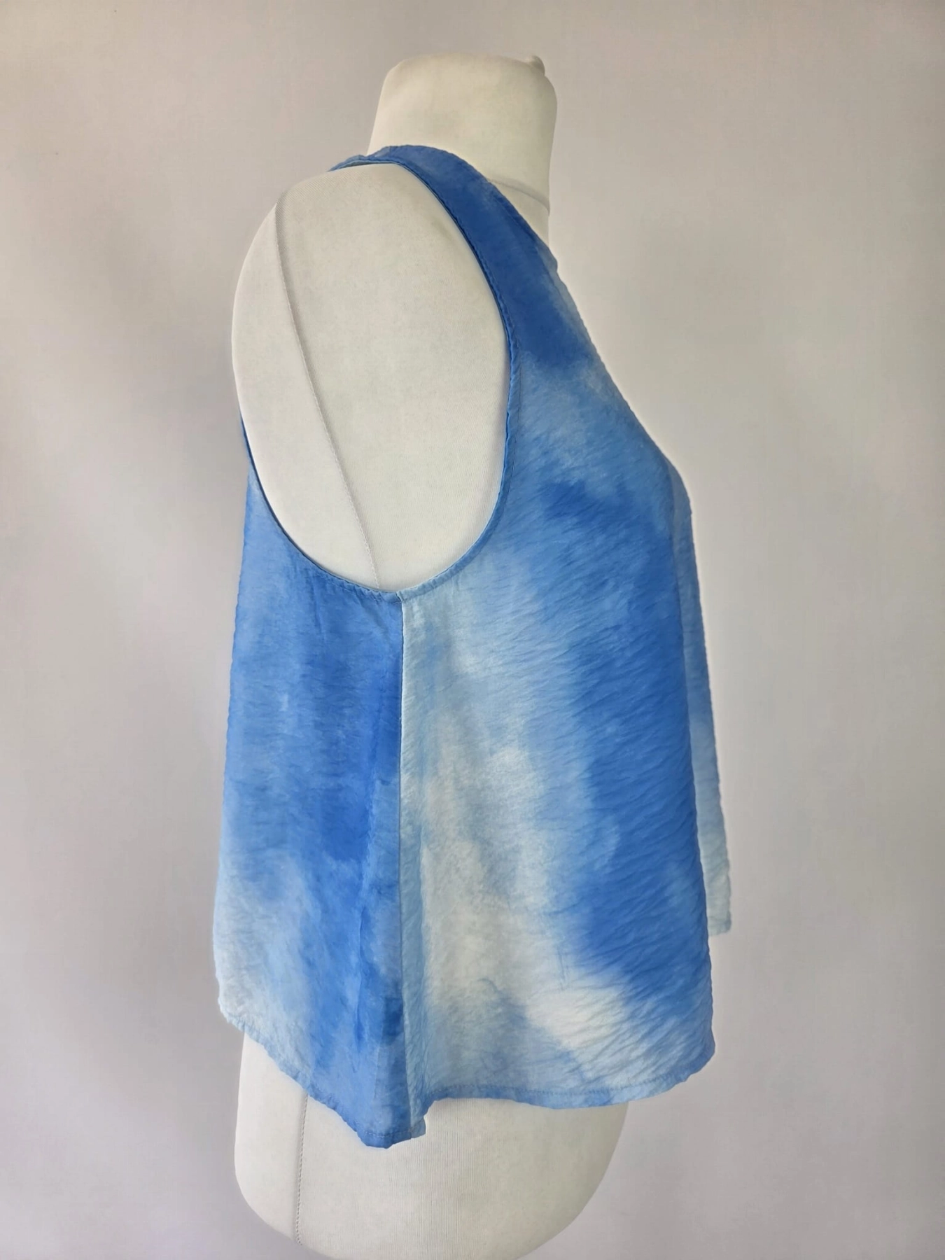 Niebieska damska bluzka bez rękawów we wzór tie-dye, wykonana z wiskozy, o luźnym kroju z ozdobnym rozcięciem na plecach, idealna do letnich stylizacji premium