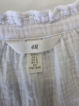Biała, muślinowa bluzka damska H&amp;M z dekoltem V i ozdobną stójką to idealny wybór na lato, łączący styl casual premium z wyjątkową wygodą