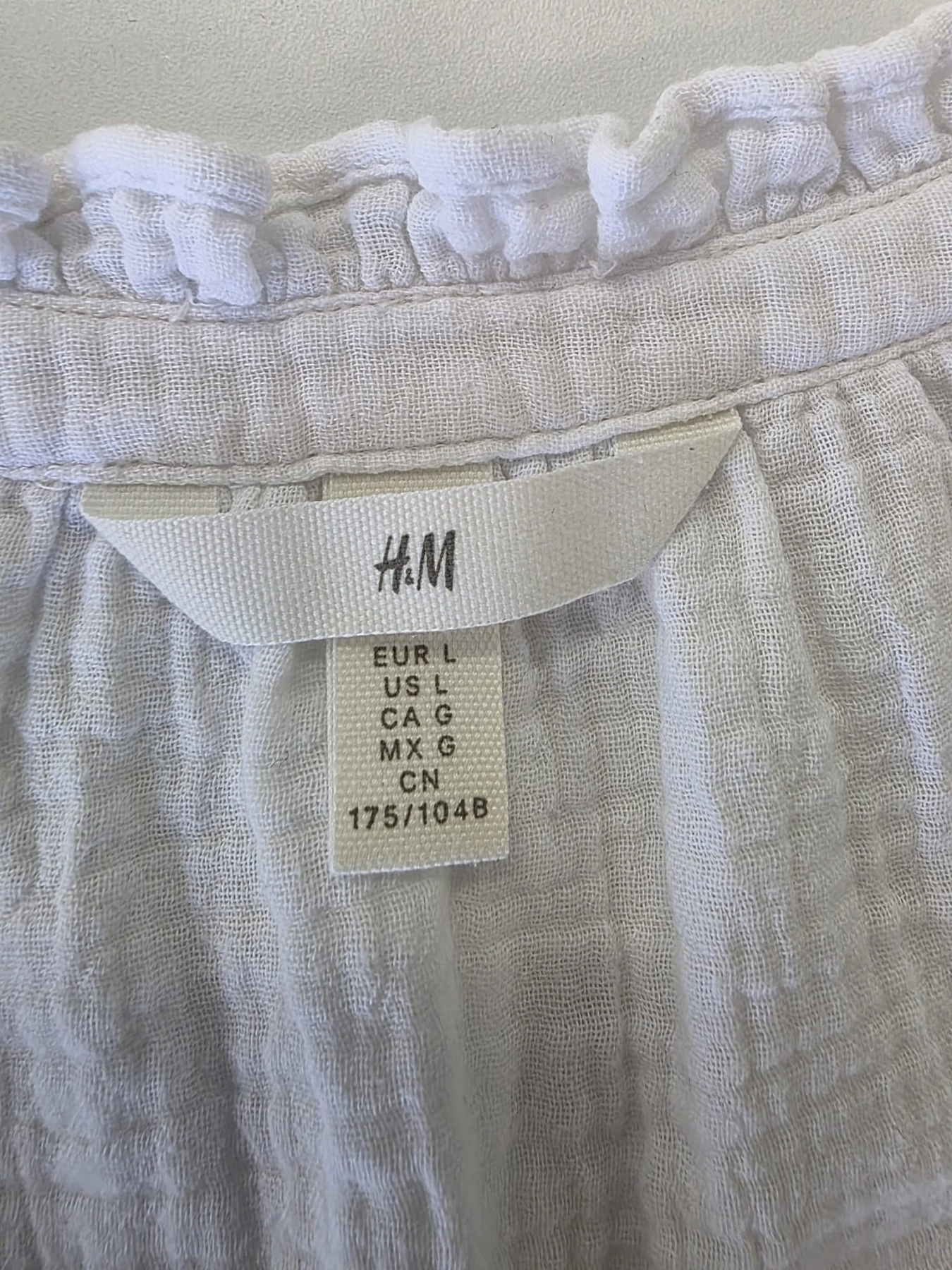 Biała, muślinowa bluzka damska H&amp;M z dekoltem V i ozdobną stójką to idealny wybór na lato, łączący styl casual premium z wyjątkową wygodą