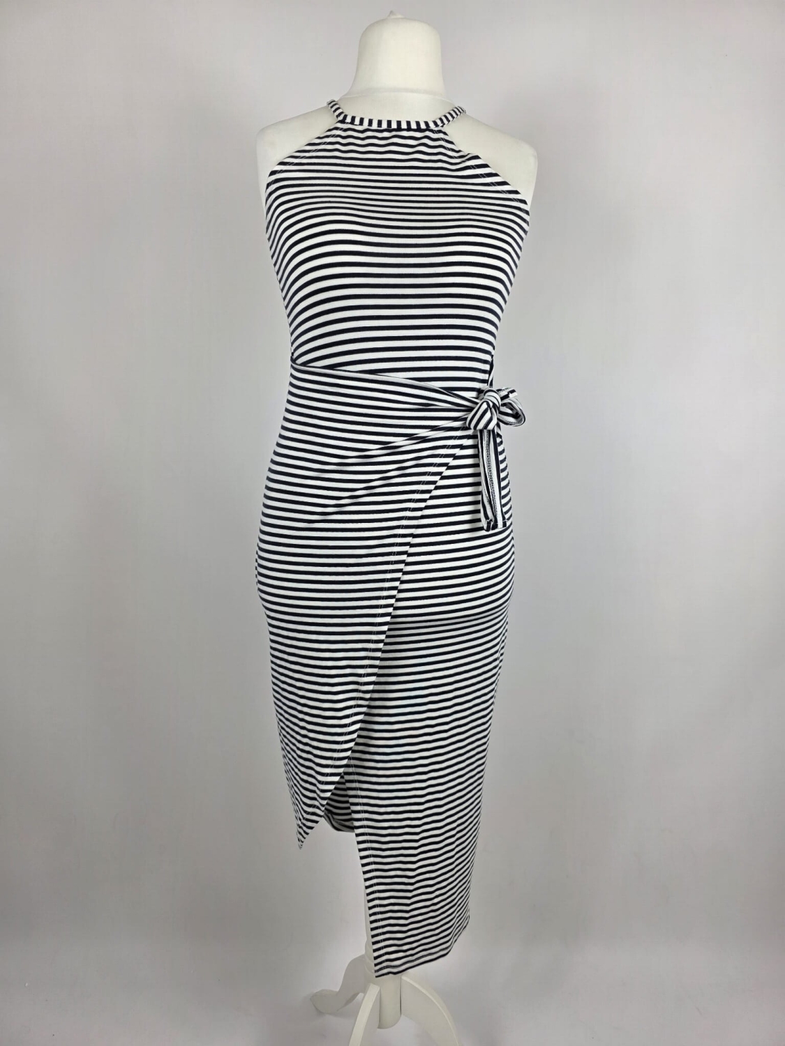 Dopasowana sukienka midi w paski marki Fame Fashion z dekoltem halter i wiązaniem w talii to idealna propozycja premium, która podkreśli kobiece kształty i zapewni modny, letni look.