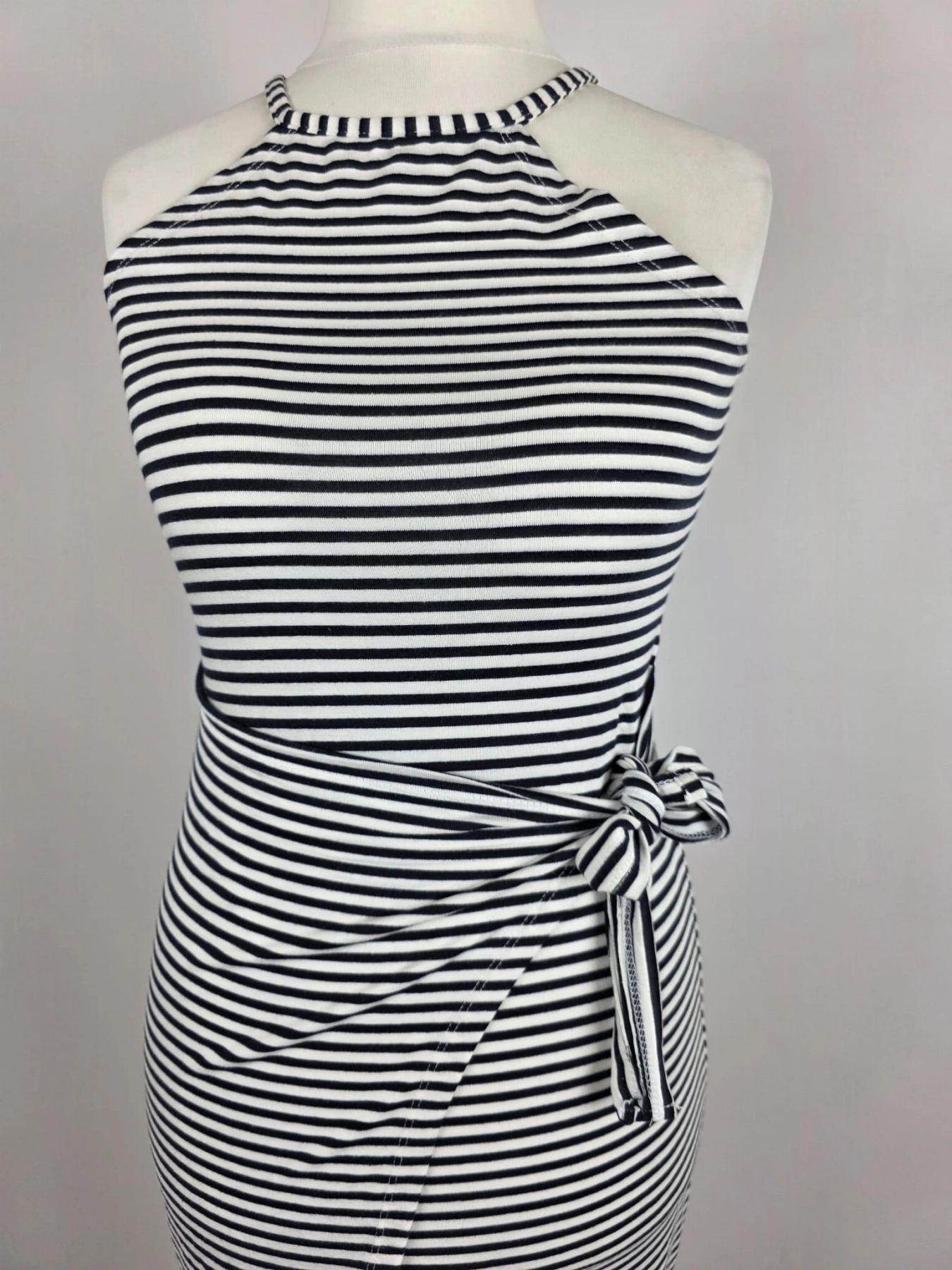 Dopasowana sukienka midi w paski marki Fame Fashion z dekoltem halter i wiązaniem w talii to idealna propozycja premium, która podkreśli kobiece kształty i zapewni modny, letni look.