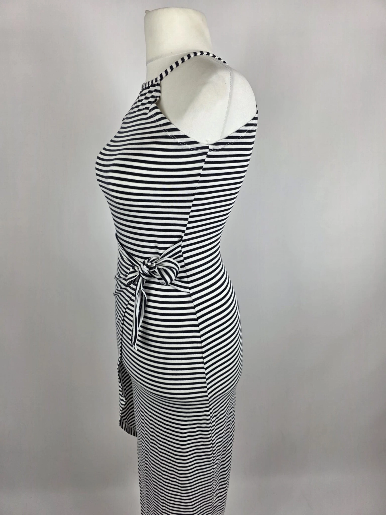 Dopasowana sukienka midi w paski marki Fame Fashion z dekoltem halter i wiązaniem w talii to idealna propozycja premium, która podkreśli kobiece kształty i zapewni modny, letni look.