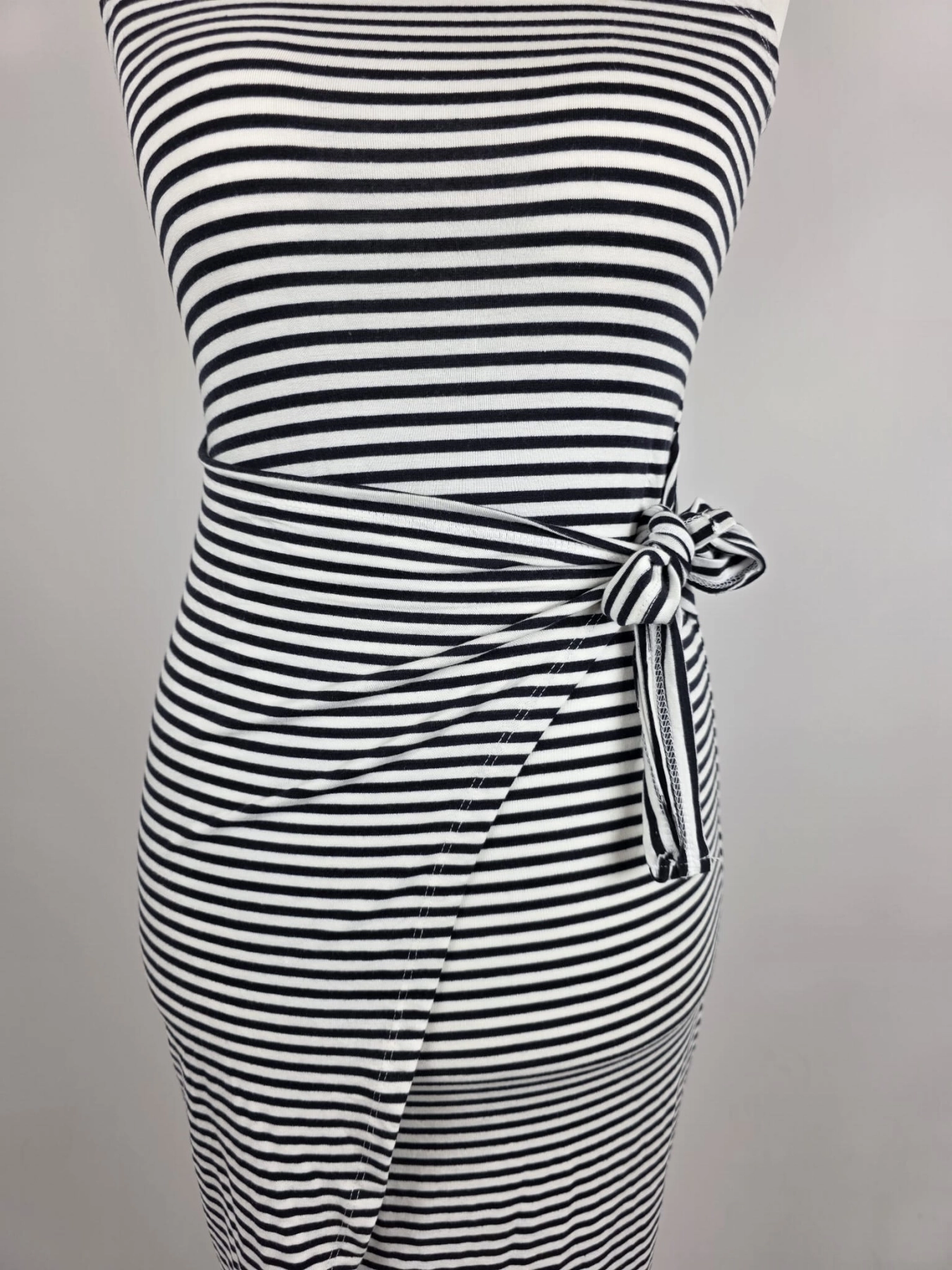 Dopasowana sukienka midi w paski marki Fame Fashion z dekoltem halter i wiązaniem w talii to idealna propozycja premium, która podkreśli kobiece kształty i zapewni modny, letni look.