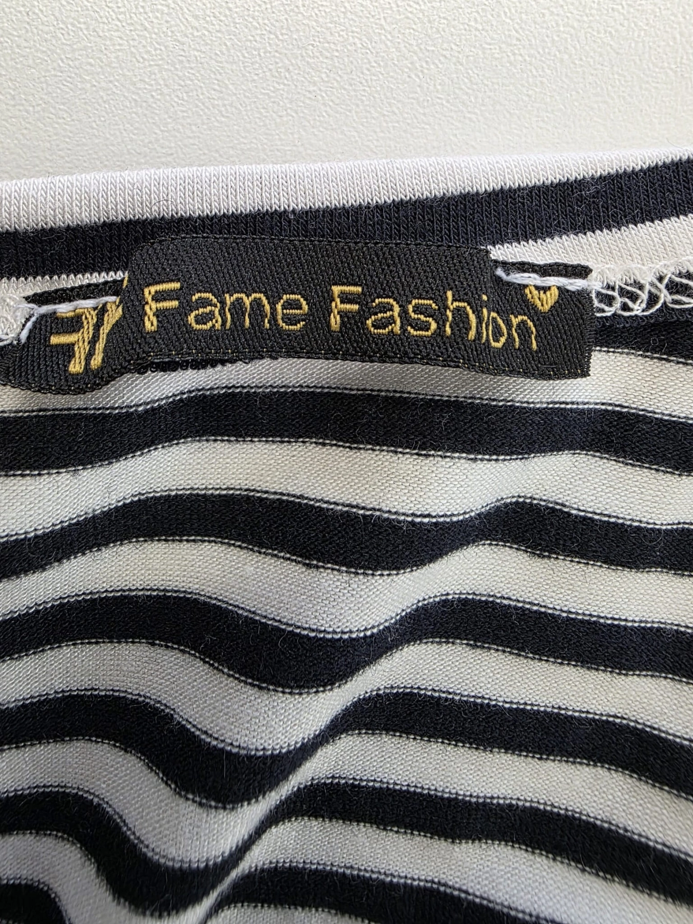 Dopasowana sukienka midi w paski marki Fame Fashion z dekoltem halter i wiązaniem w talii to idealna propozycja premium, która podkreśli kobiece kształty i zapewni modny, letni look.