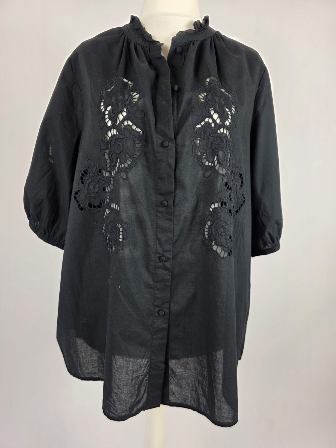 Czarna, bawełniana bluzka plus size marki xlnt z haftem angielskim i elegancką stójką to stylowy oraz niezwykle wygodny wybór, który doskonale uzupełni każdą kobiecą stylizację premium