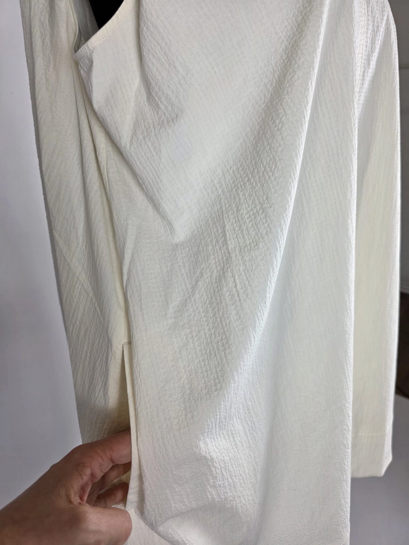 Kremowa sukienka oversize marki COS o gofrowanej strukturze, z dekoltem w serek i wiązaniem na plecach, idealna do minimalistycznych, letnich stylizacji premium